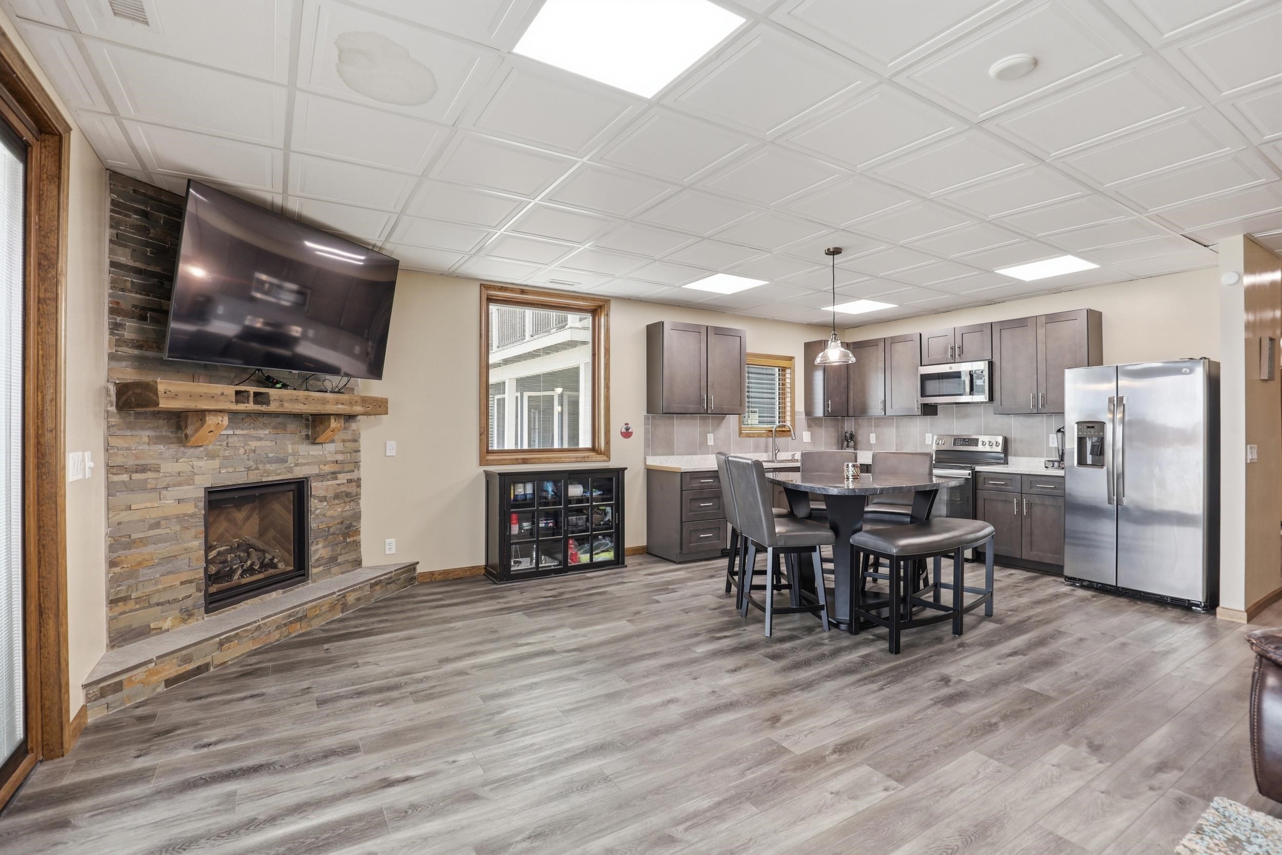 Dining space featuring a stone fireplace and light wood-style flooring