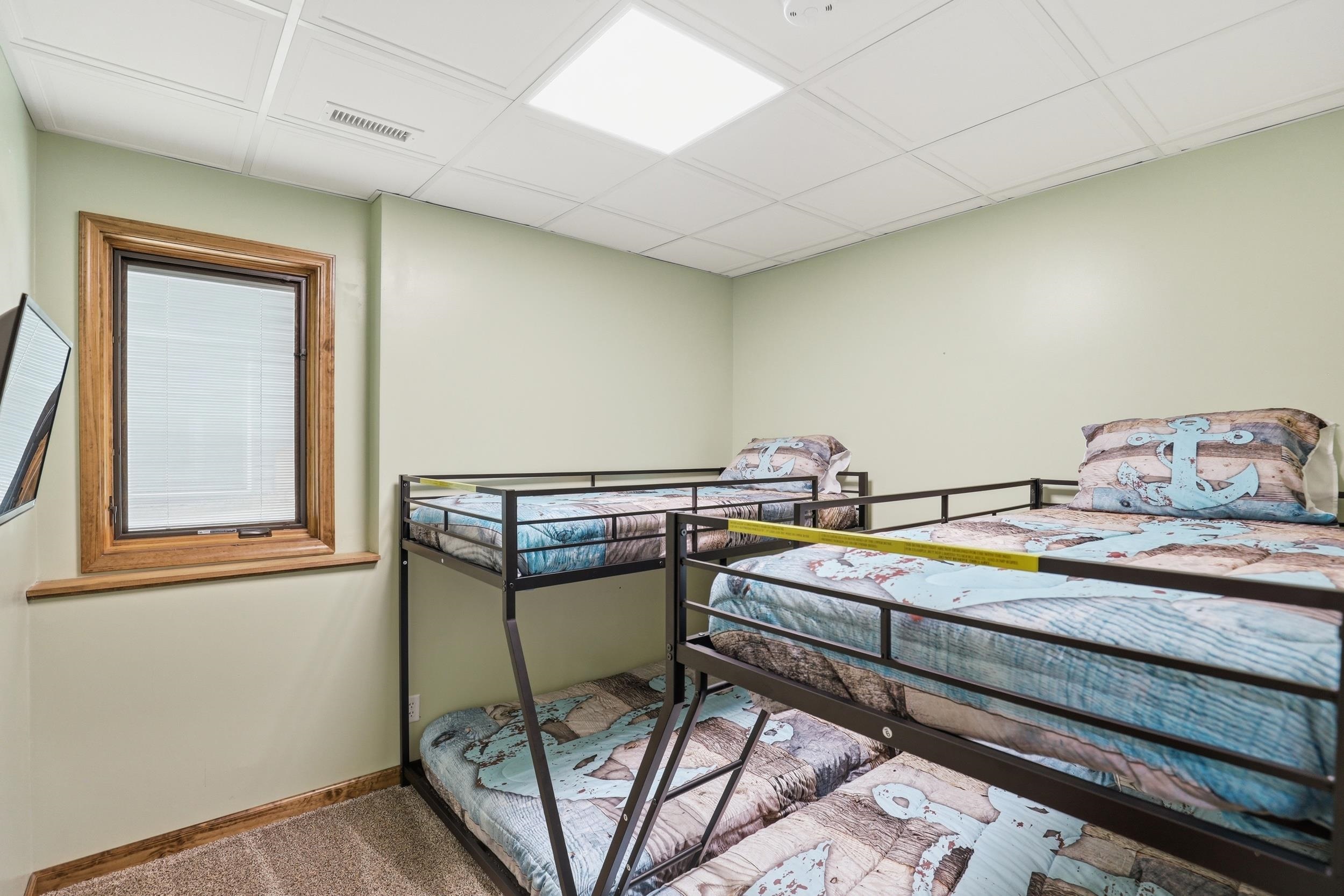 Carpeted bedroom featuring a drop ceiling and baseboards
