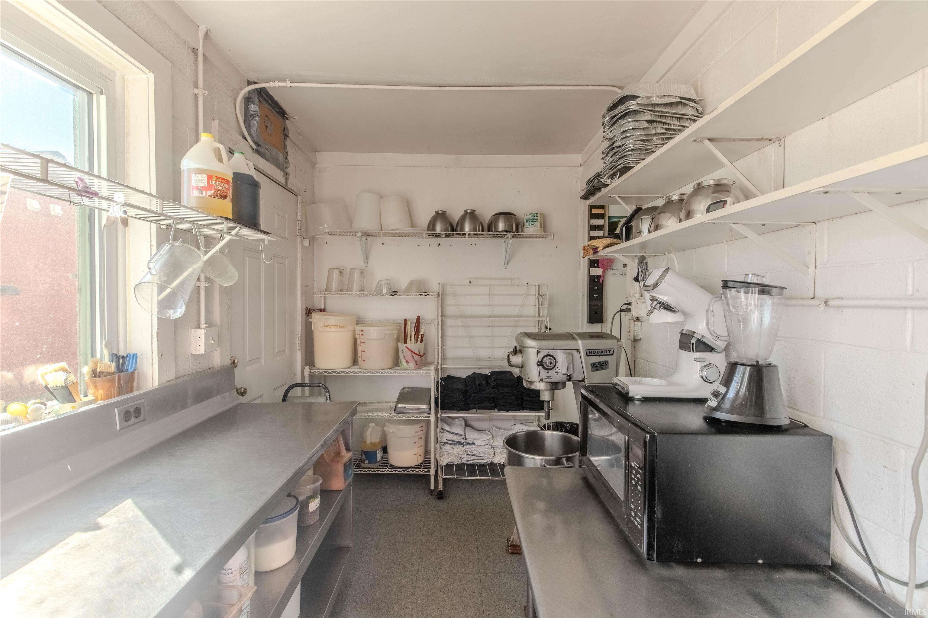 Kitchen featuring black microwave and dark colored carpet