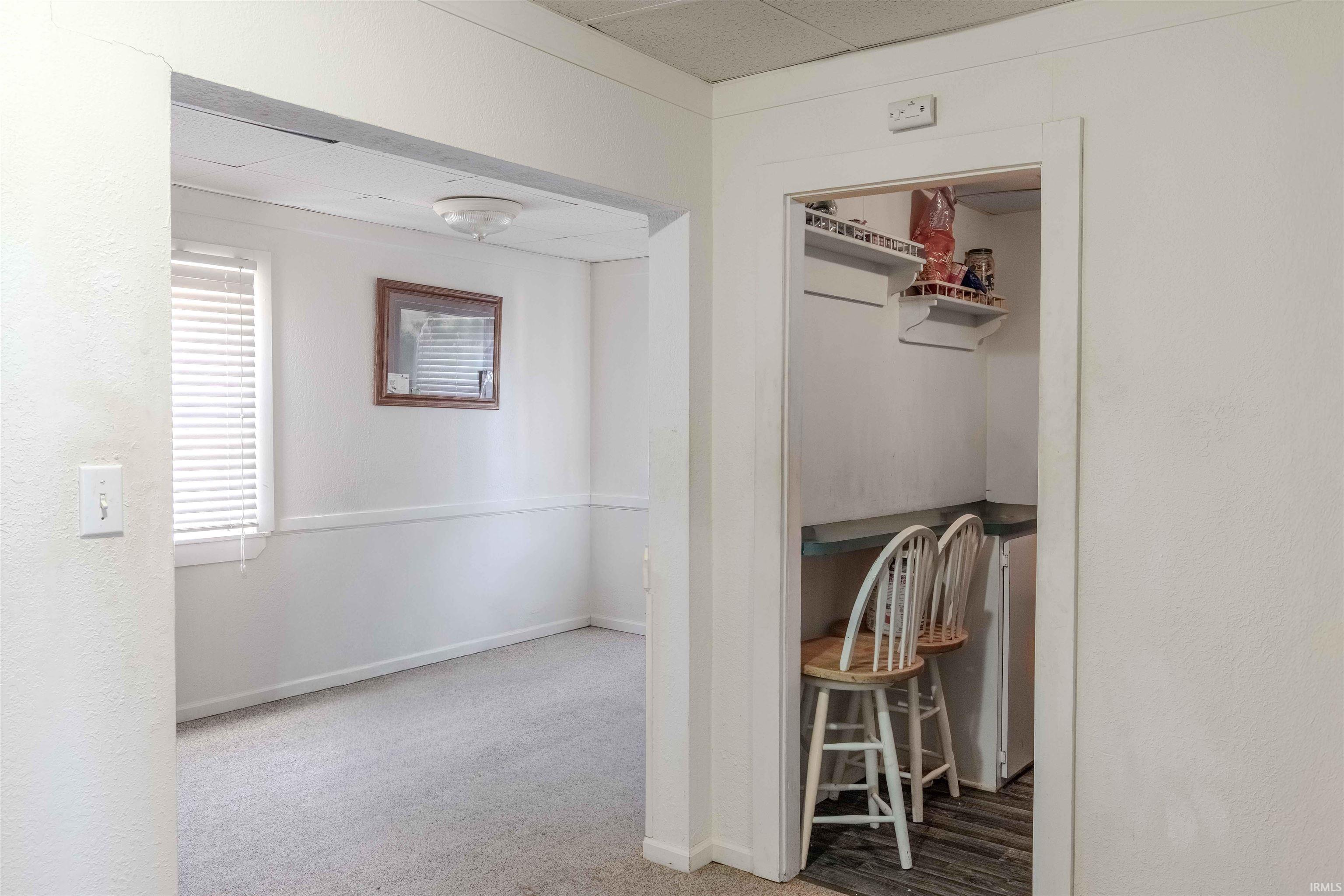 Hallway with light carpet and baseboards
