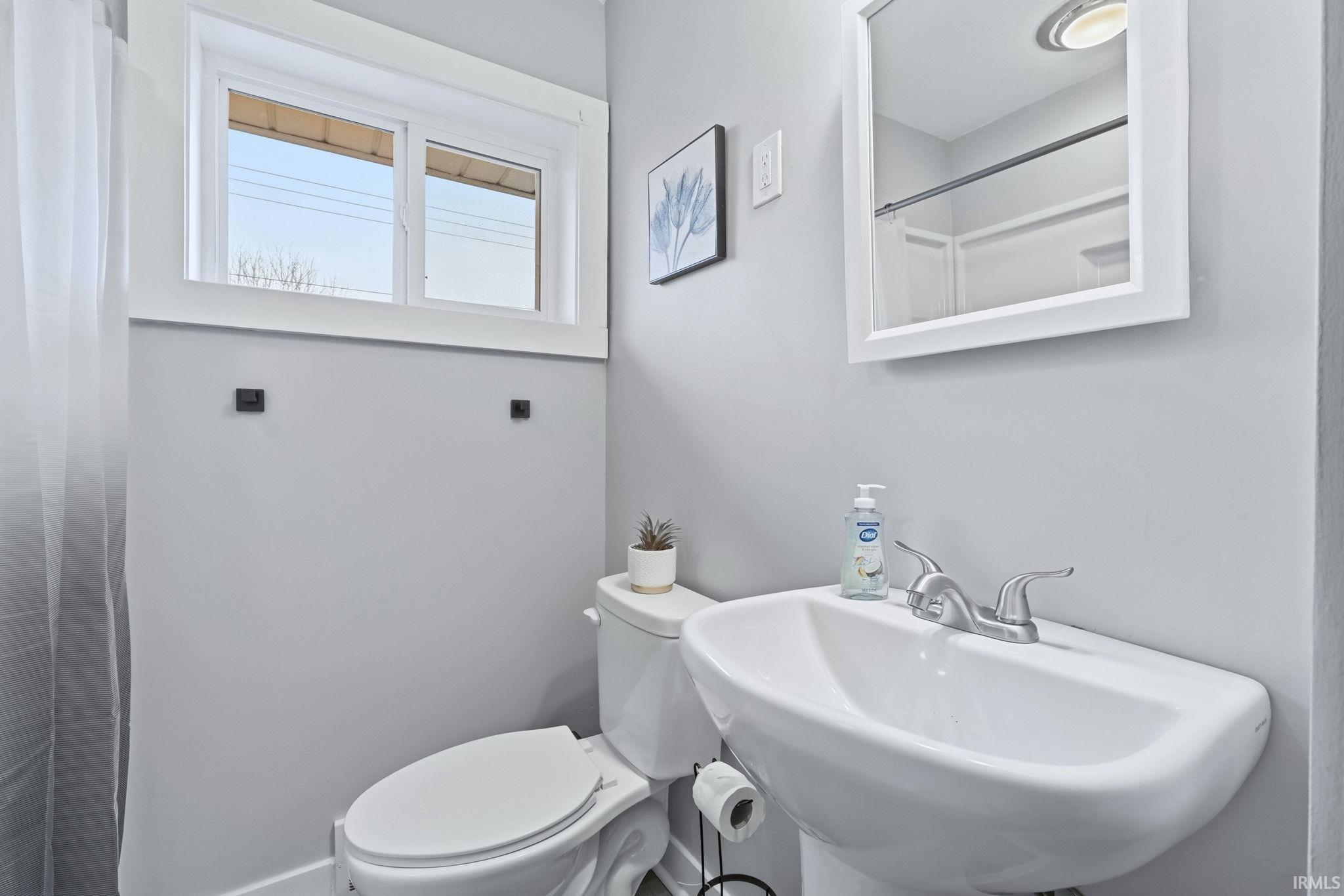 Full bathroom featuring toilet and a shower with curtain