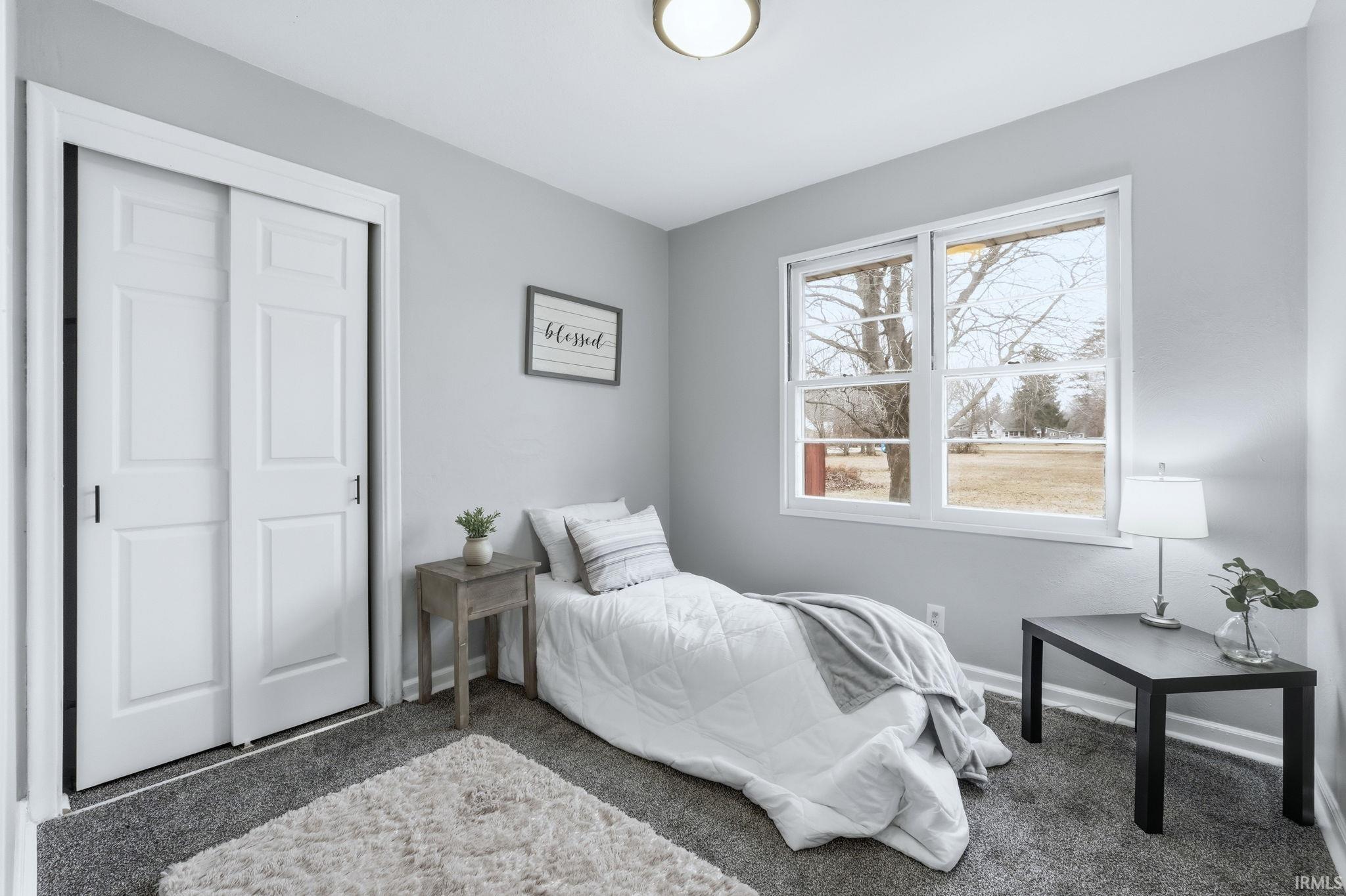 Carpeted bedroom featuring baseboards and a closet