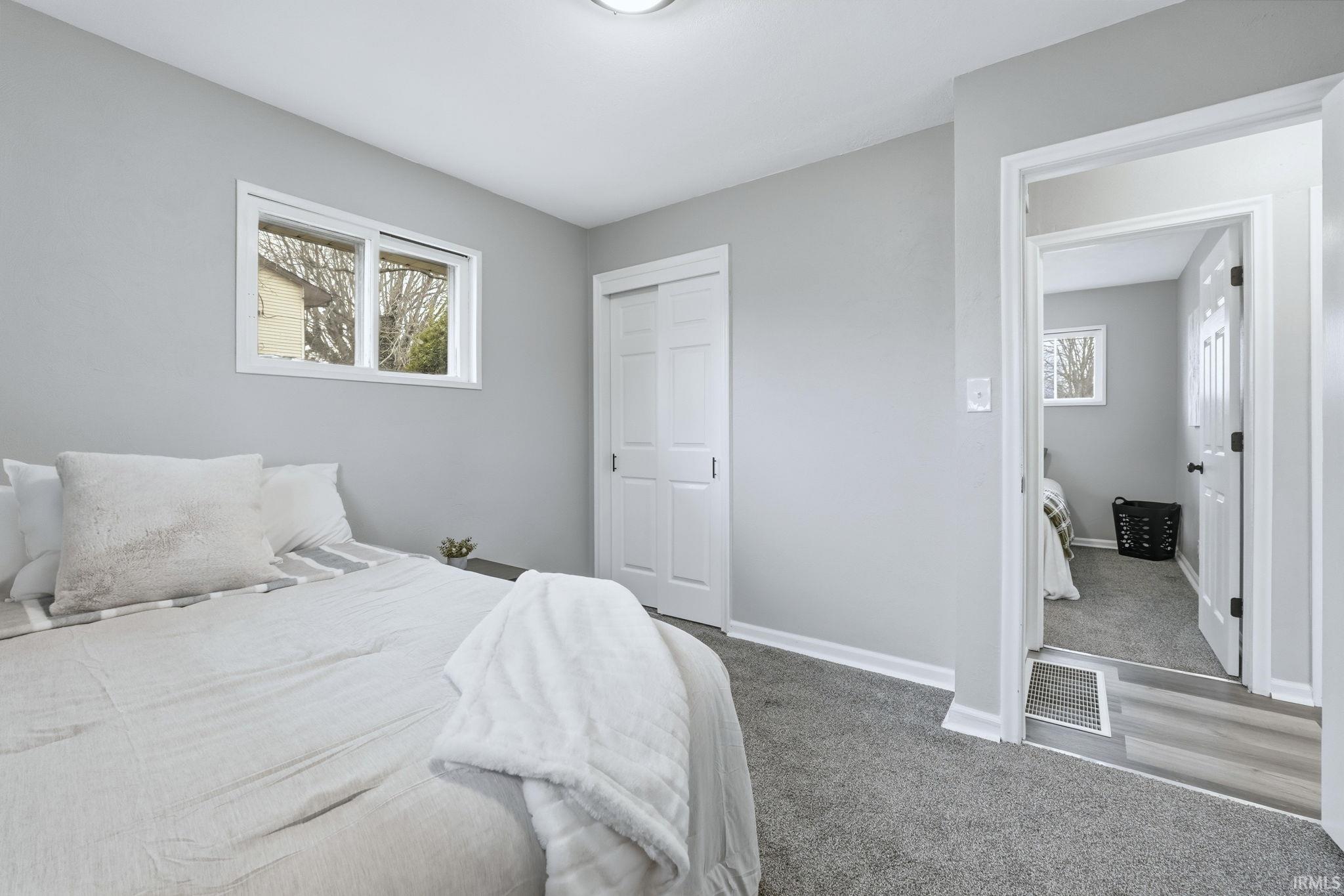 Carpeted bedroom with baseboards and a closet