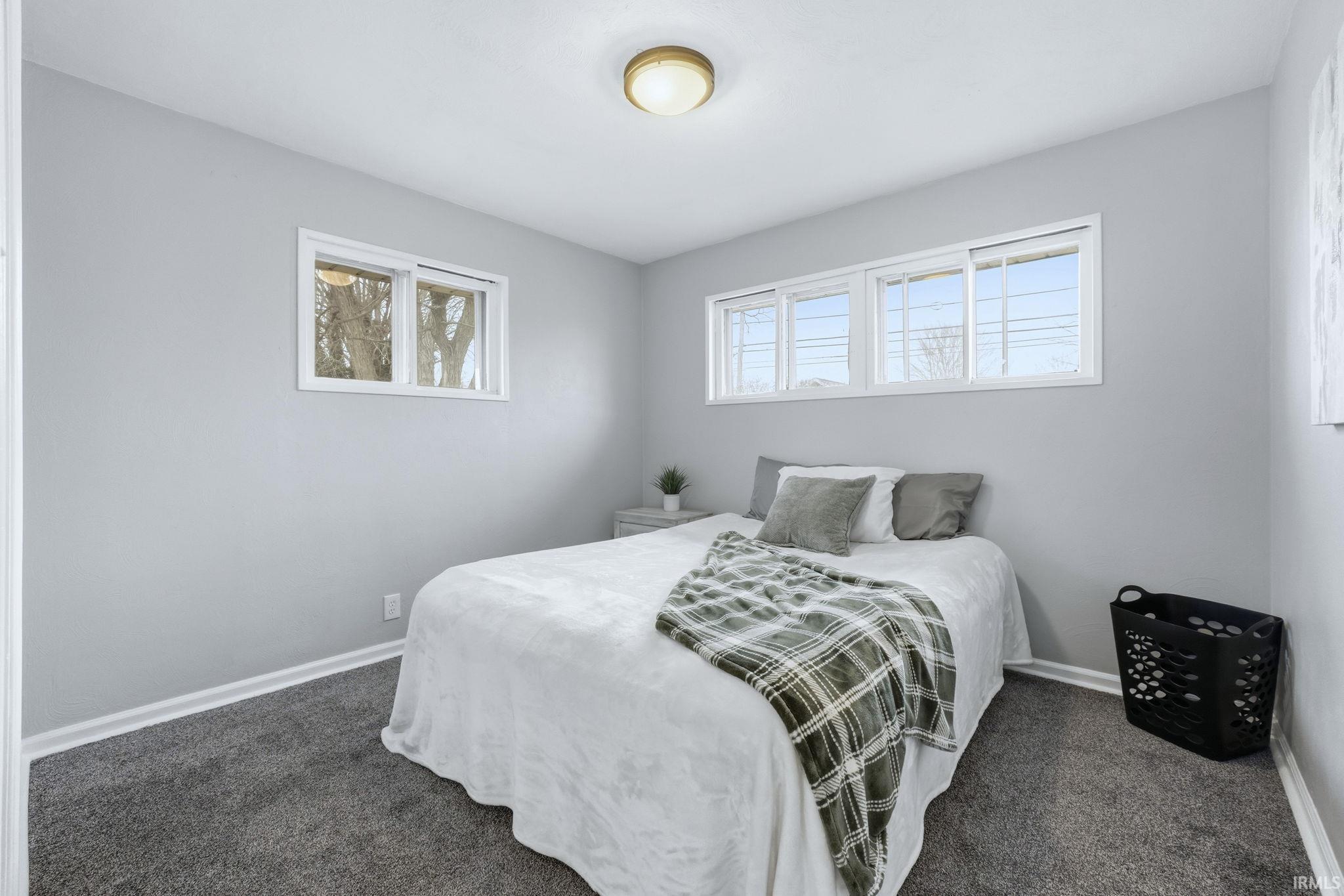 Bedroom featuring baseboards and dark colored carpet