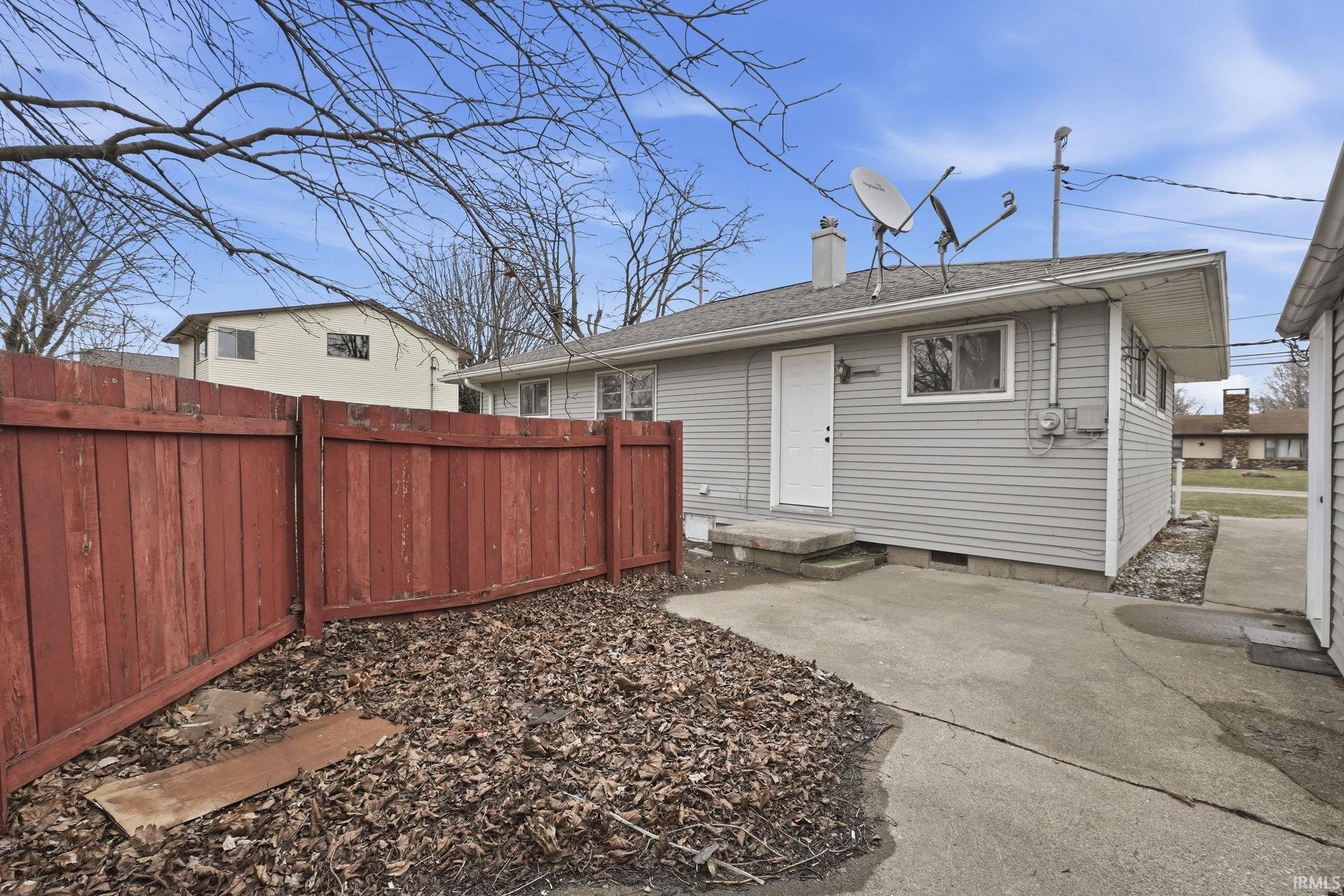 Rear view of property with a chimney, a patio area, roof with shingles, and crawl space