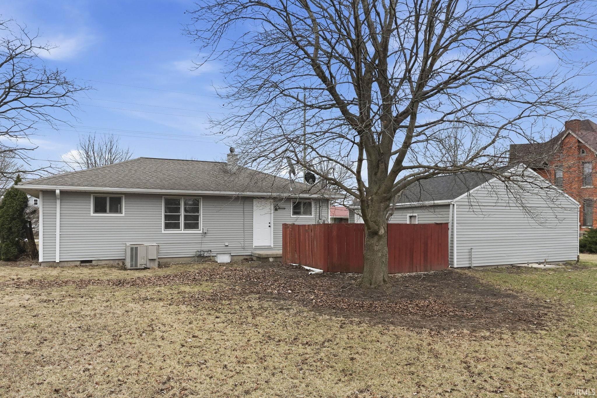 Rear view of property featuring a chimney, a shingled roof, and crawl space