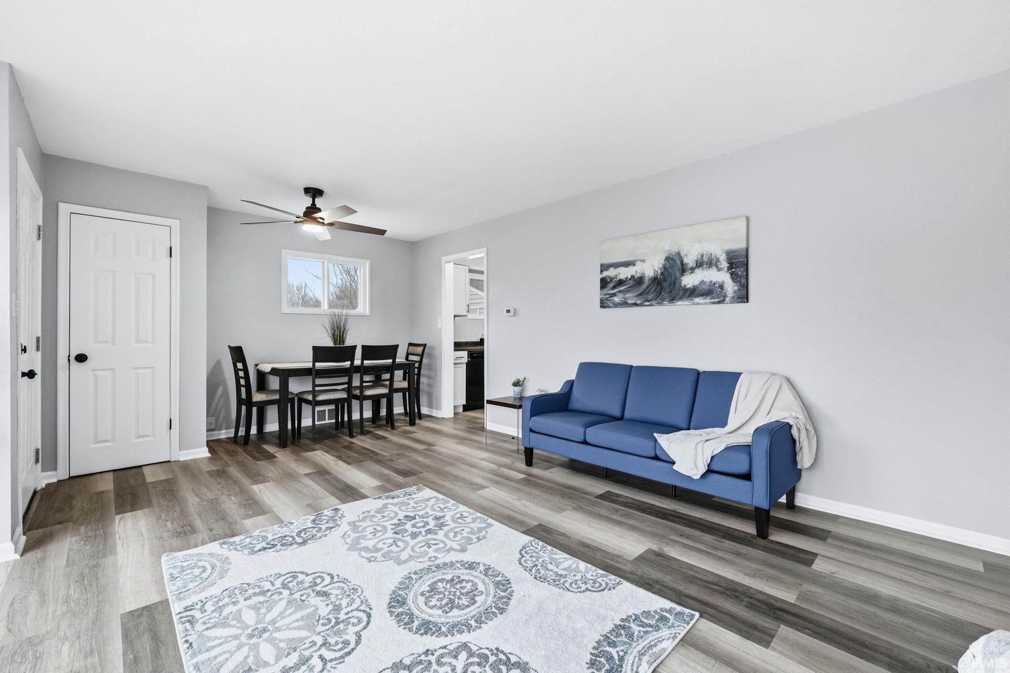 Living room with light wood-type flooring and ceiling fan