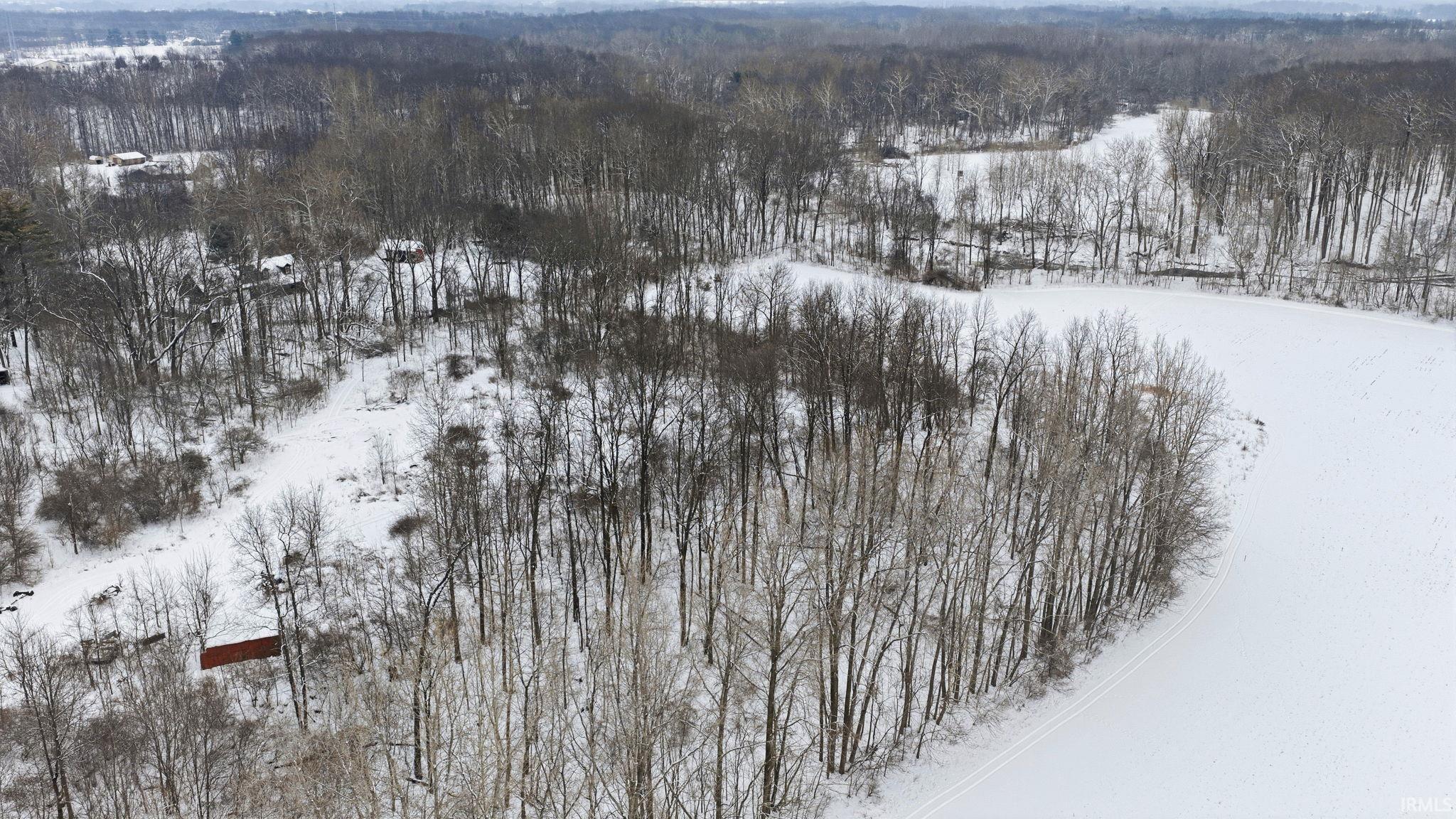 Snowy aerial view with a wooded view