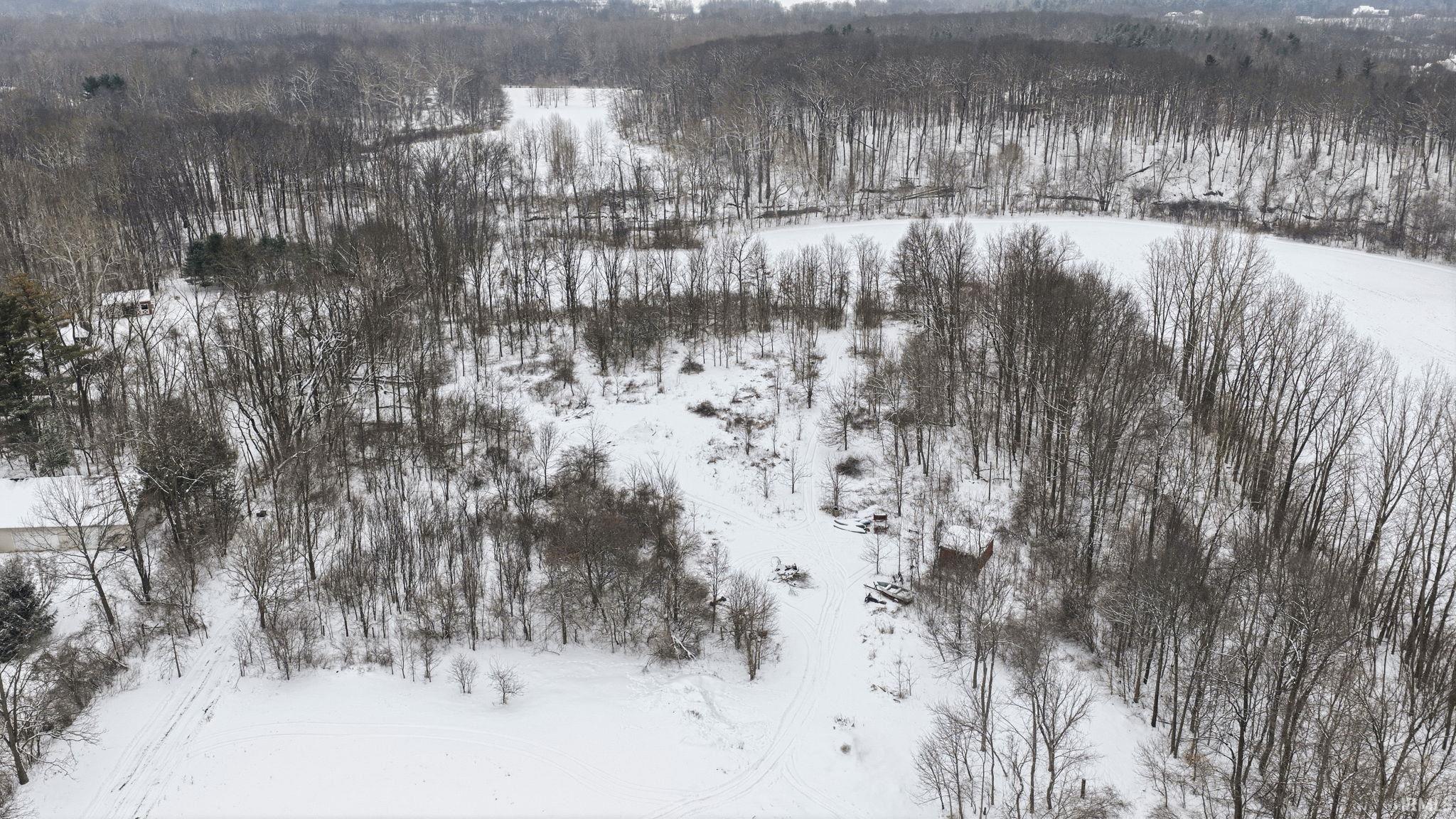 Snowy aerial view featuring a forest view