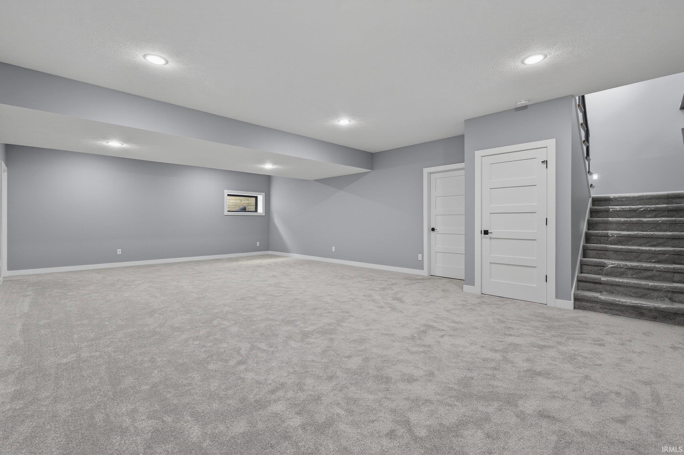 Finished below grade area with carpet flooring and recessed lighting