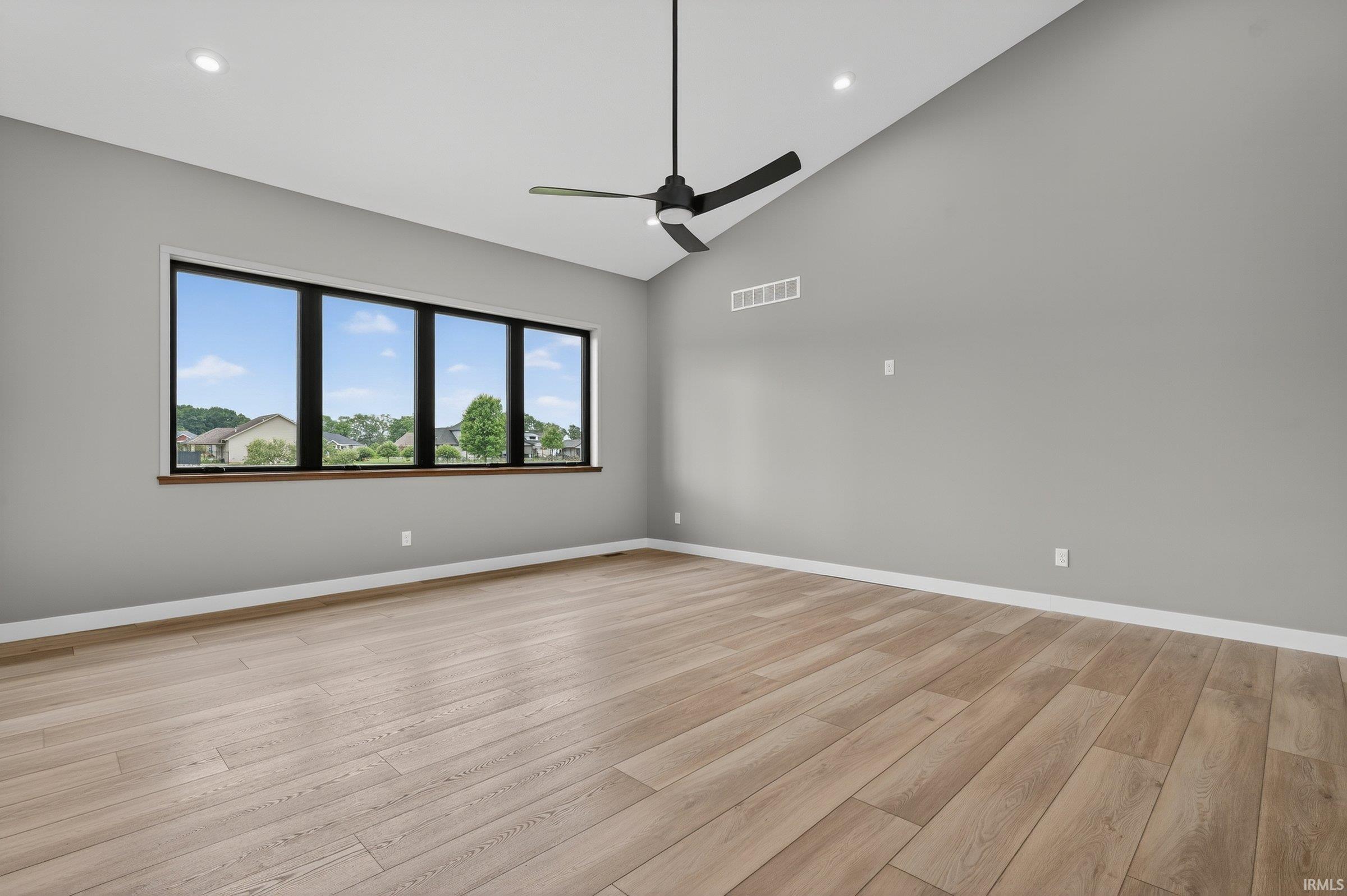 Living room featuring vaulted ceiling, ceiling fan, light wood-style flooring, and recessed lighting