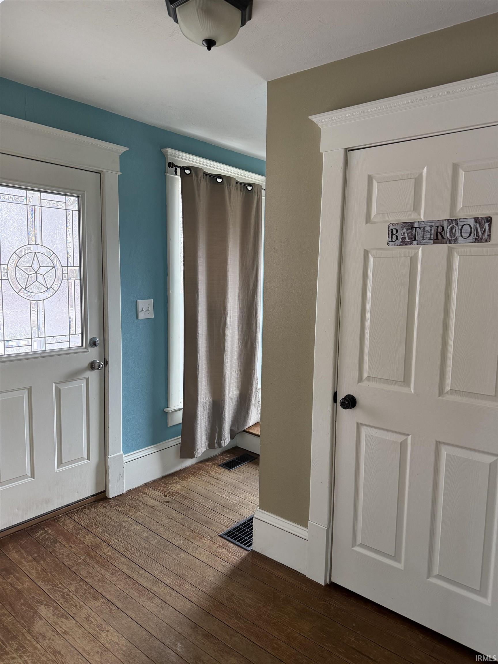 Foyer entrance with dark wood-style floors and baseboards