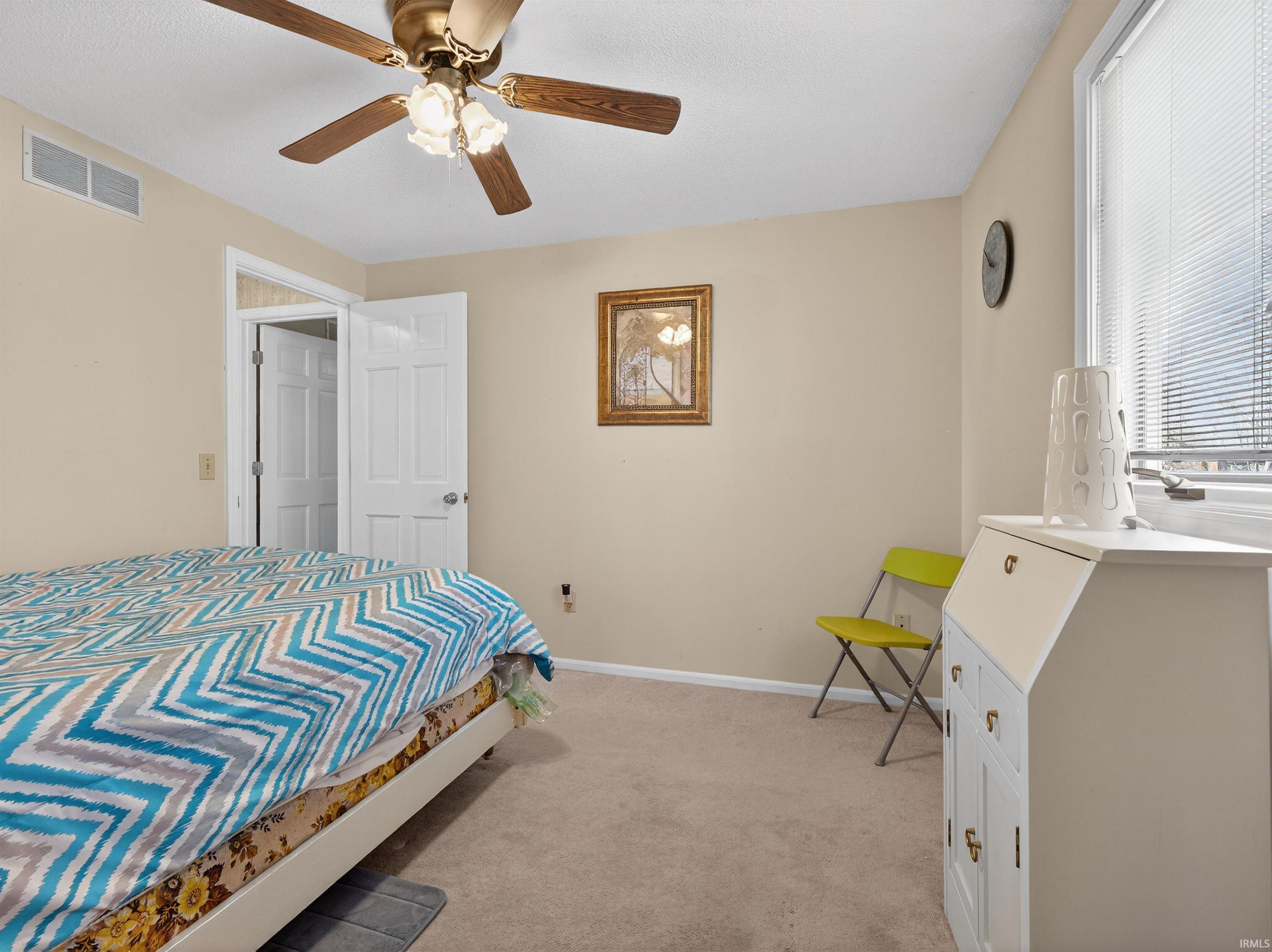 Bedroom featuring light carpet and a ceiling fan