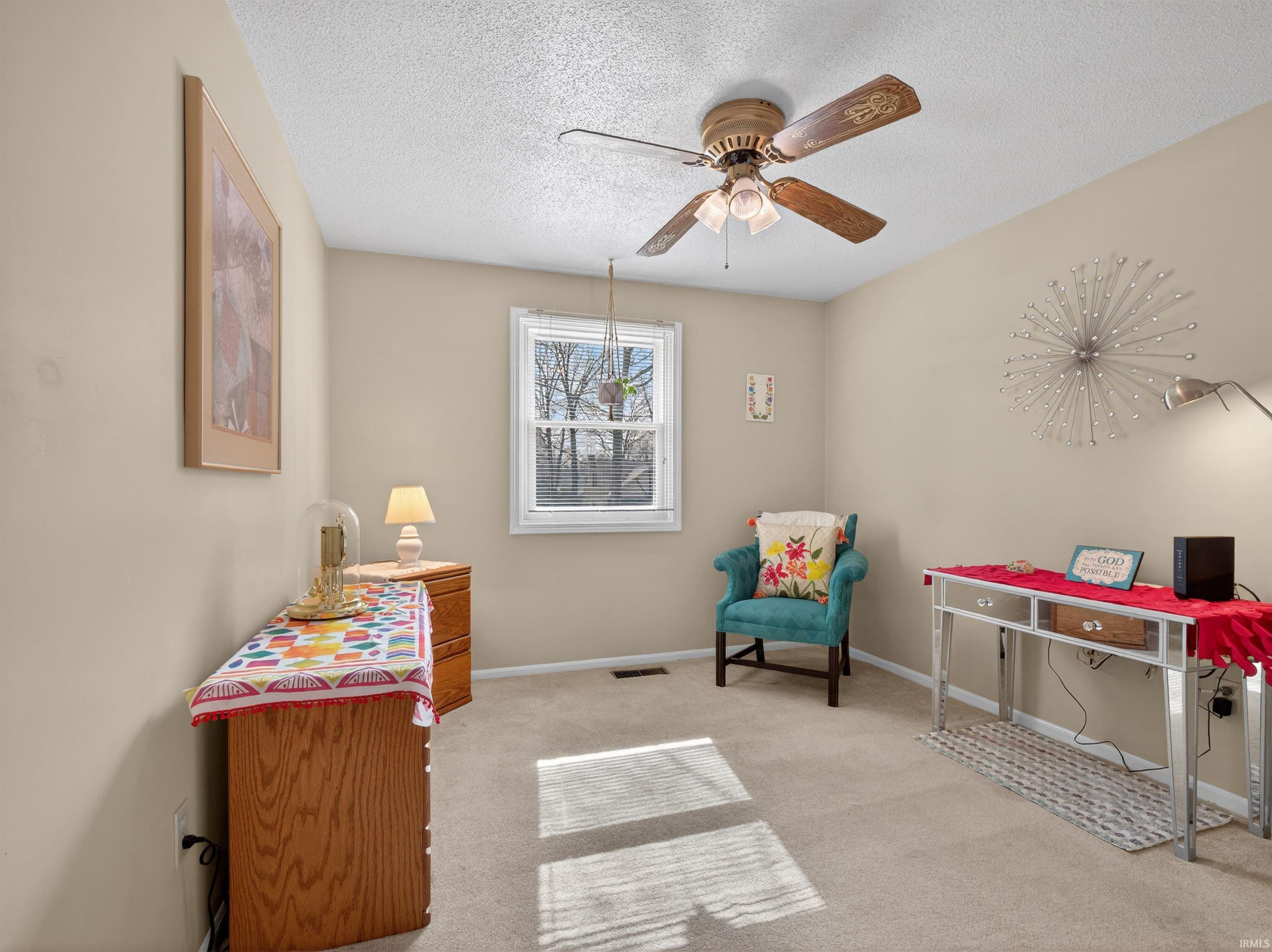 Sitting room with light carpet, a ceiling fan, and a textured ceiling
