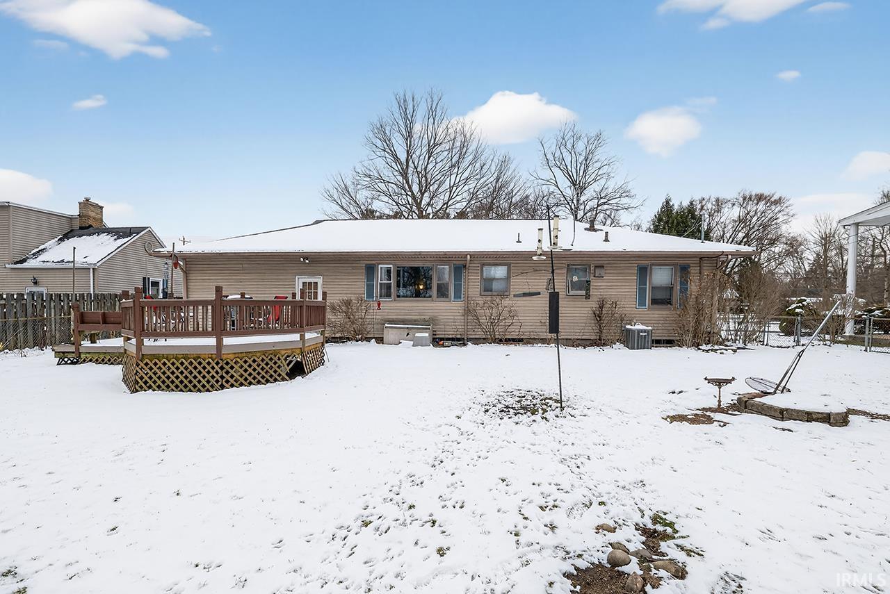 Snow covered house featuring a wooden deck