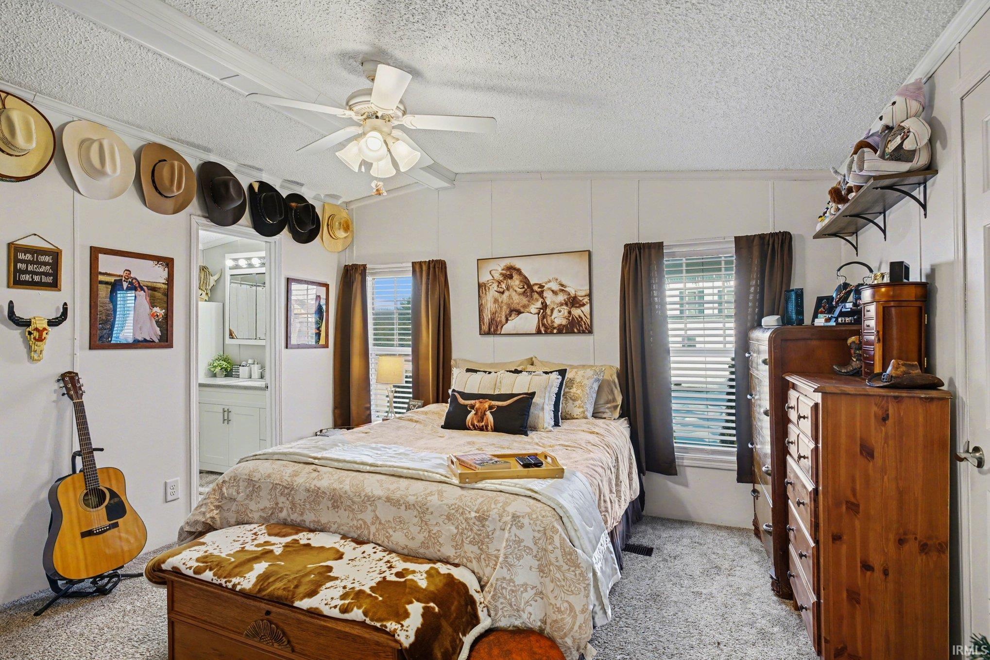 Bedroom featuring carpet floors, ceiling fan, and ensuite bathroom