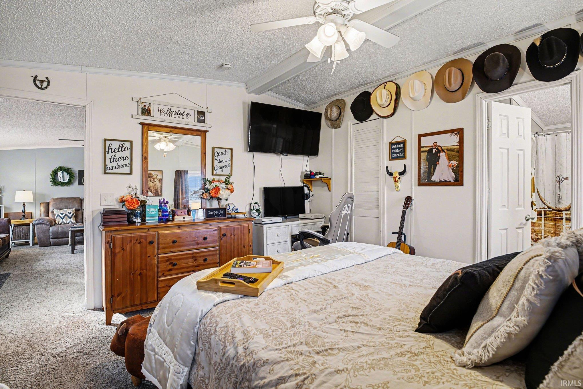 Bedroom with carpet floors, ornamental molding, and ceiling fan