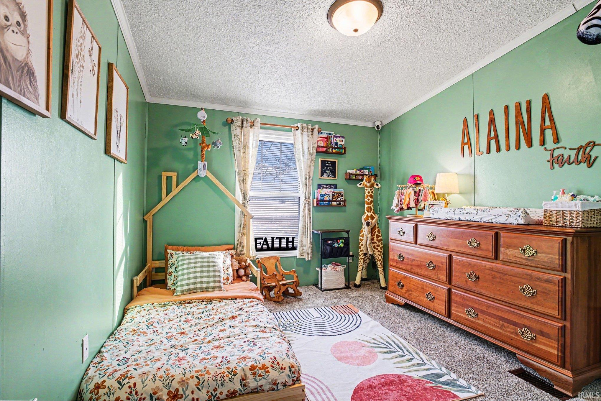Carpeted bedroom with a textured ceiling and crown molding