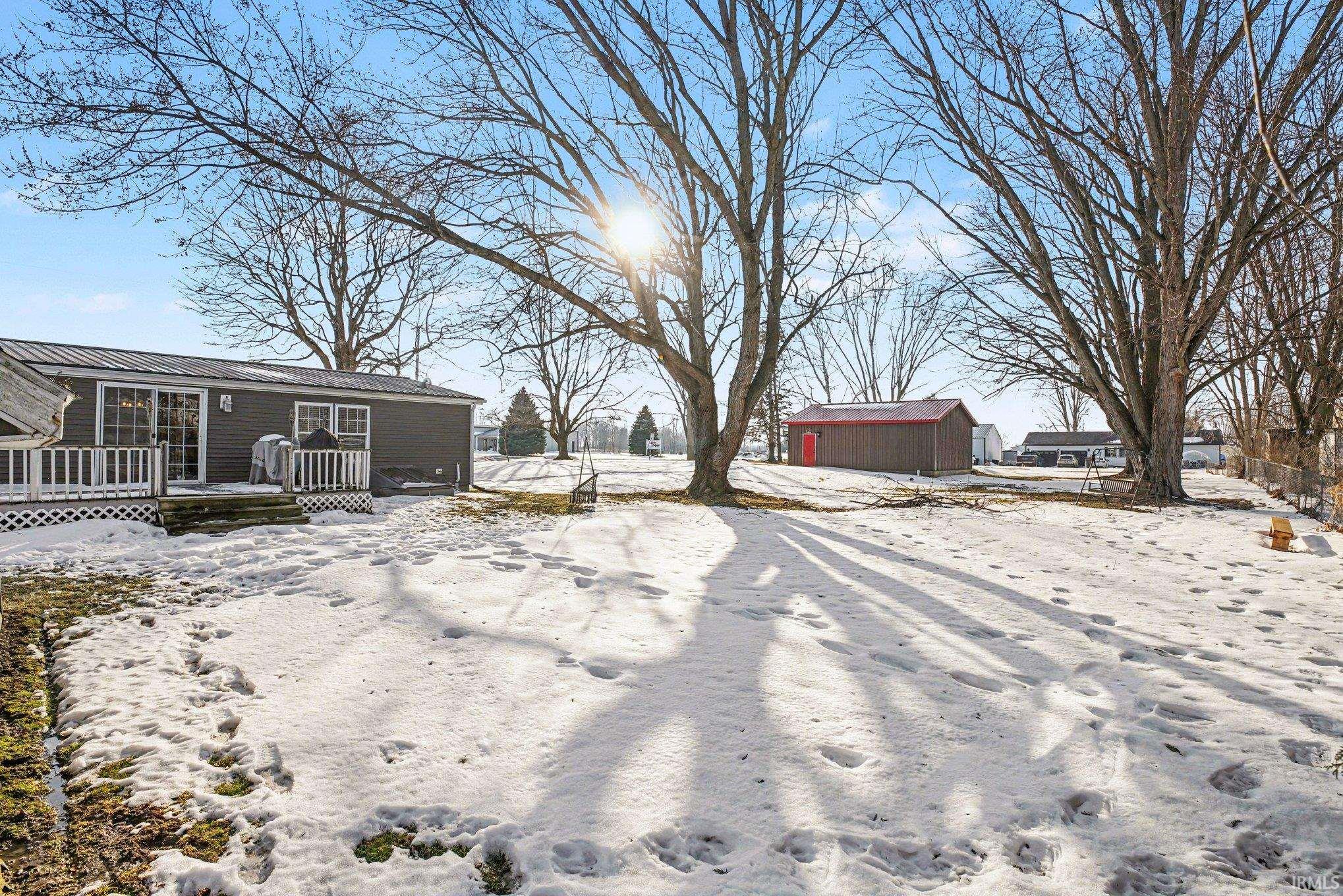 Yard layered in snow with a wooden deck