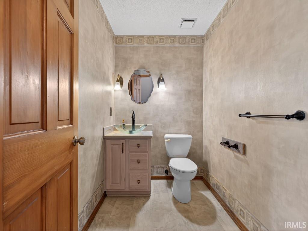 Half bathroom featuring vanity and a textured ceiling