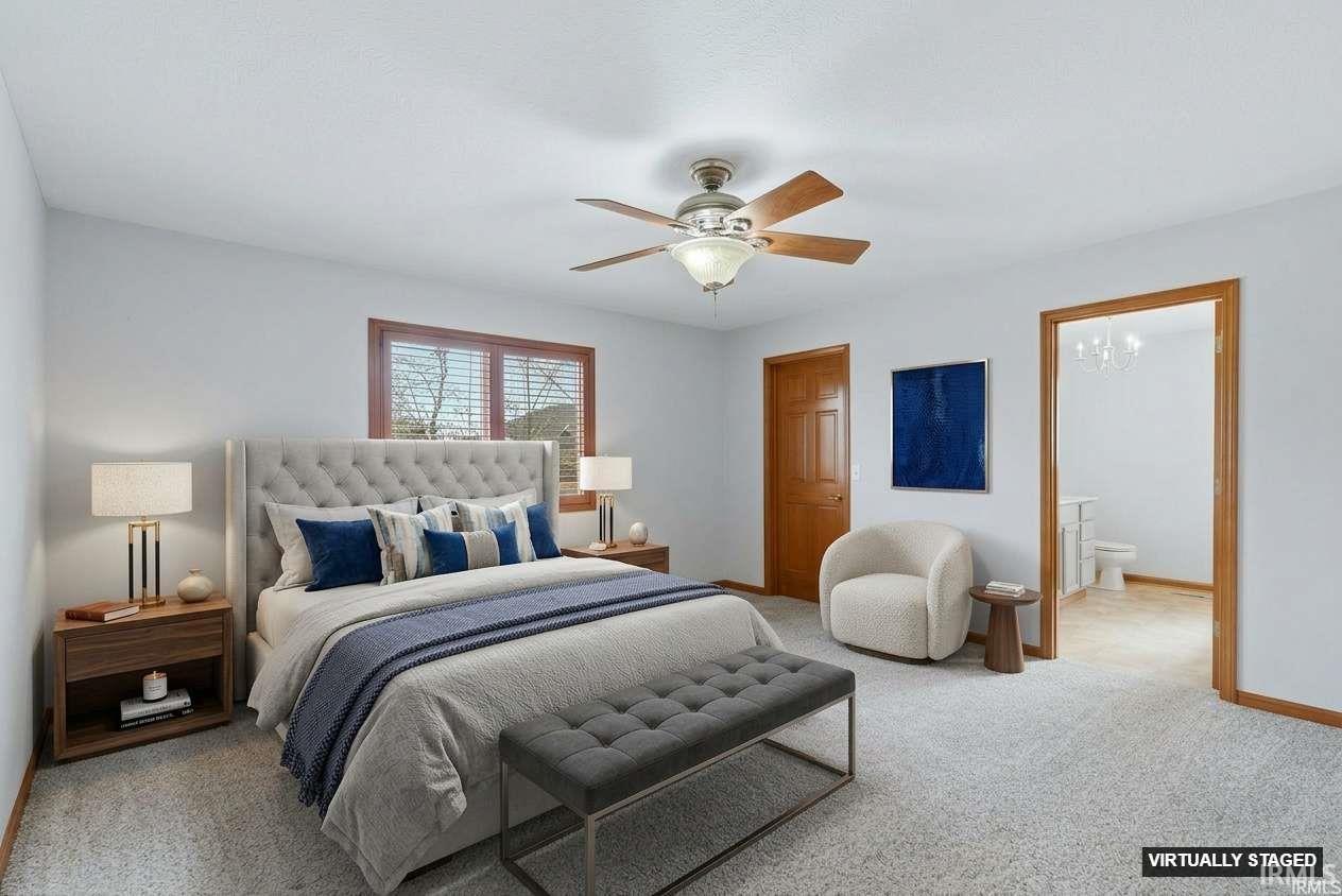 Bedroom with light carpet, ceiling fan, and ensuite bath