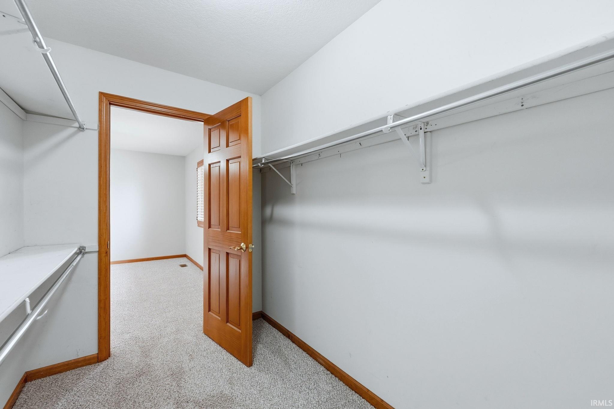 Walk in closet with light carpet