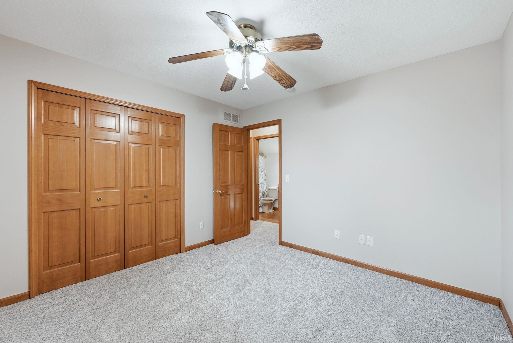 Unfurnished bedroom with carpet flooring, a ceiling fan, and a closet