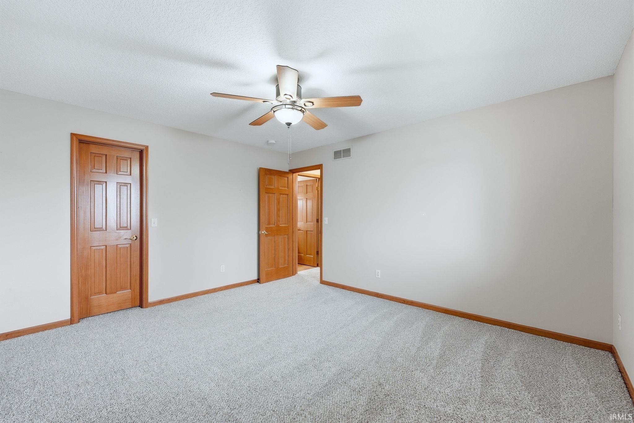 Unfurnished bedroom featuring carpet floors and ceiling fan