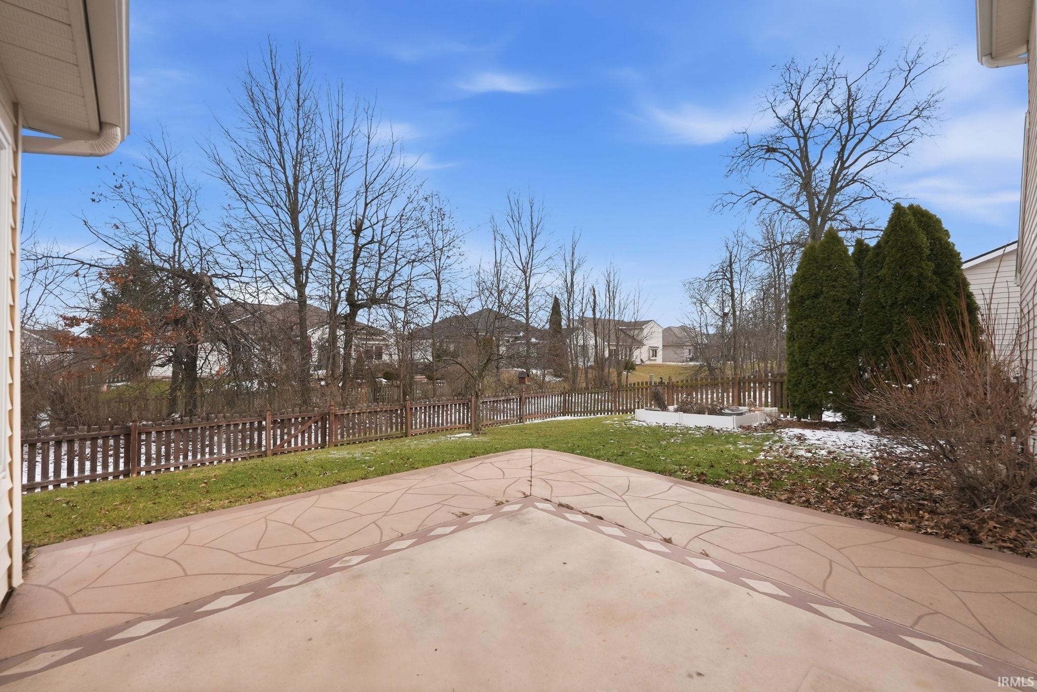 Fenced backyard featuring a patio and a residential view