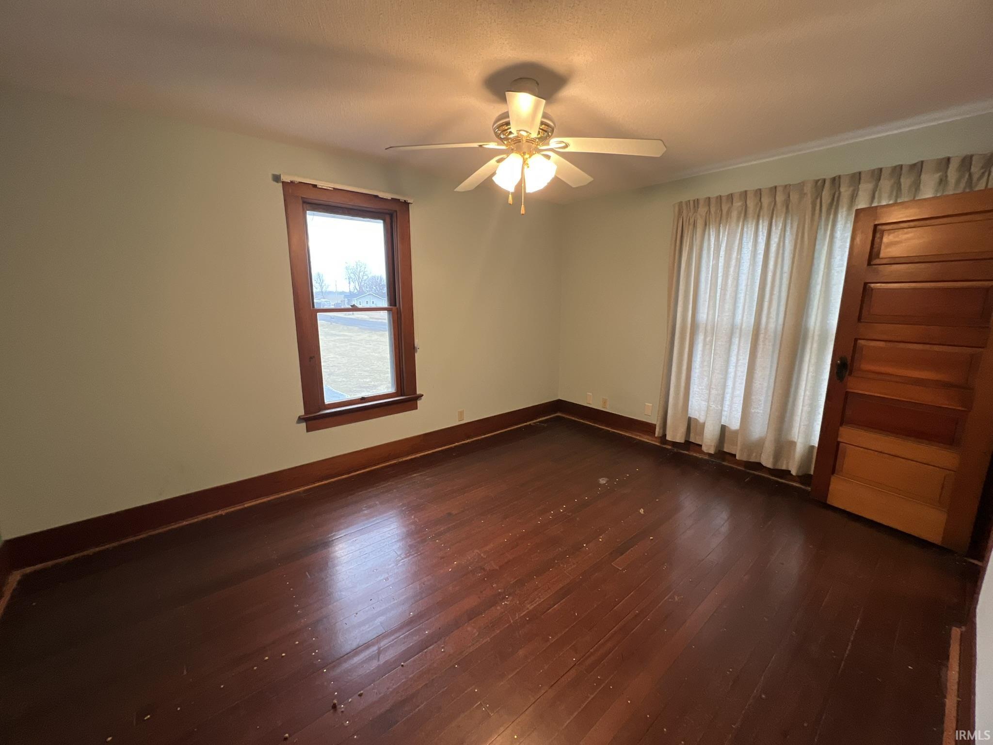 Empty room featuring dark wood finished floors and ceiling fan