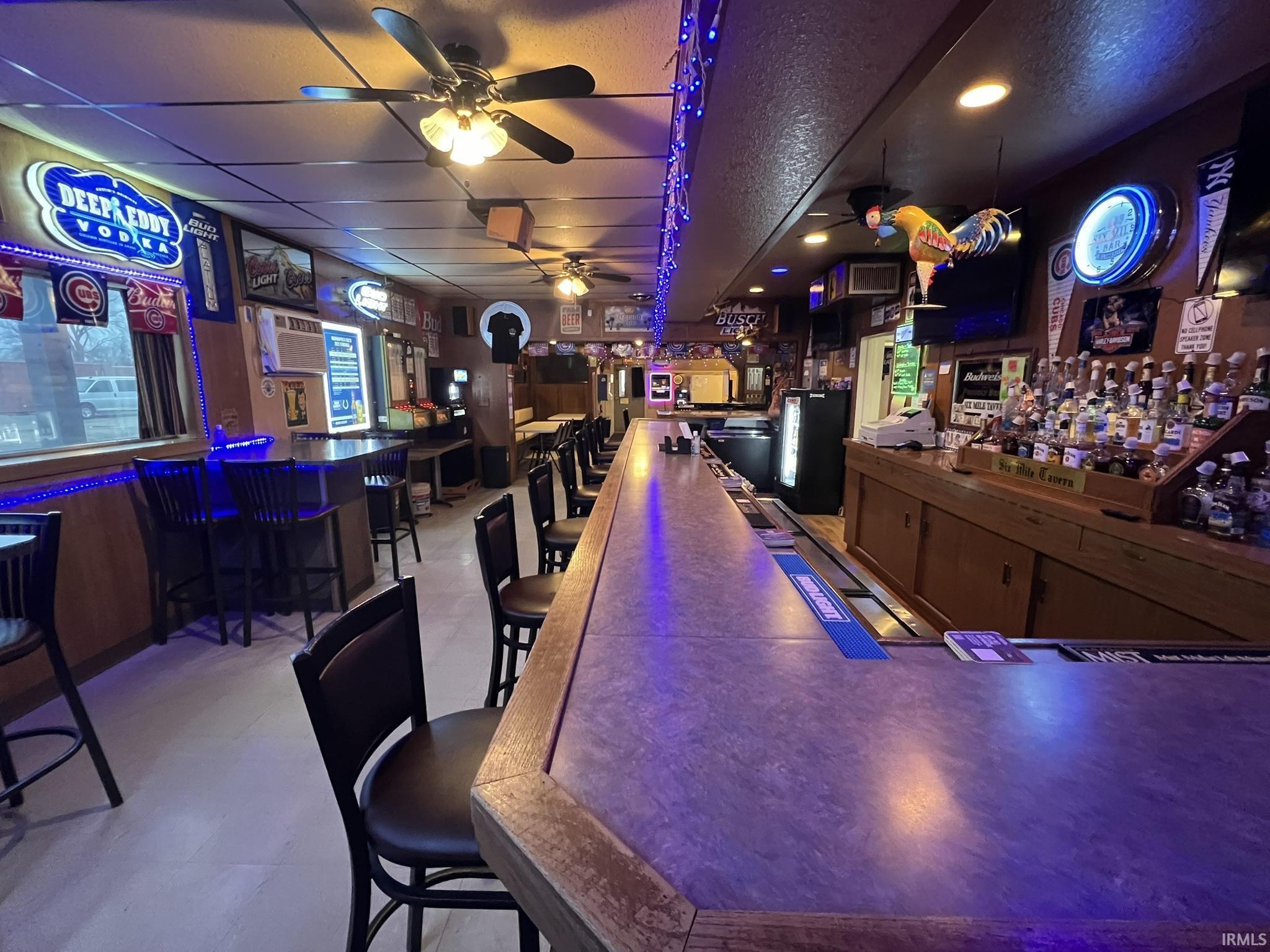 Indoor dry bar with ceiling fan and a wall unit AC