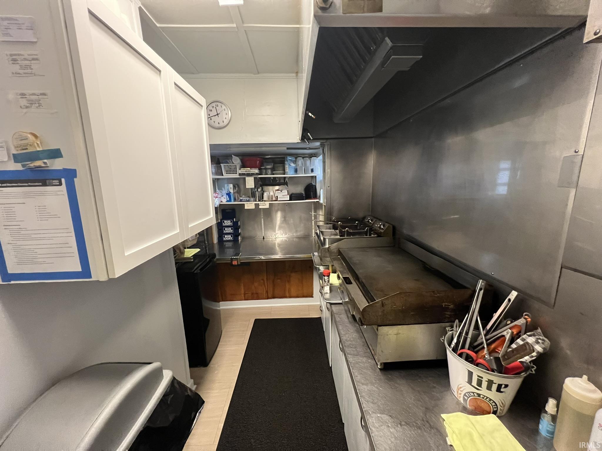 Kitchen featuring ventilation hood and black fridge