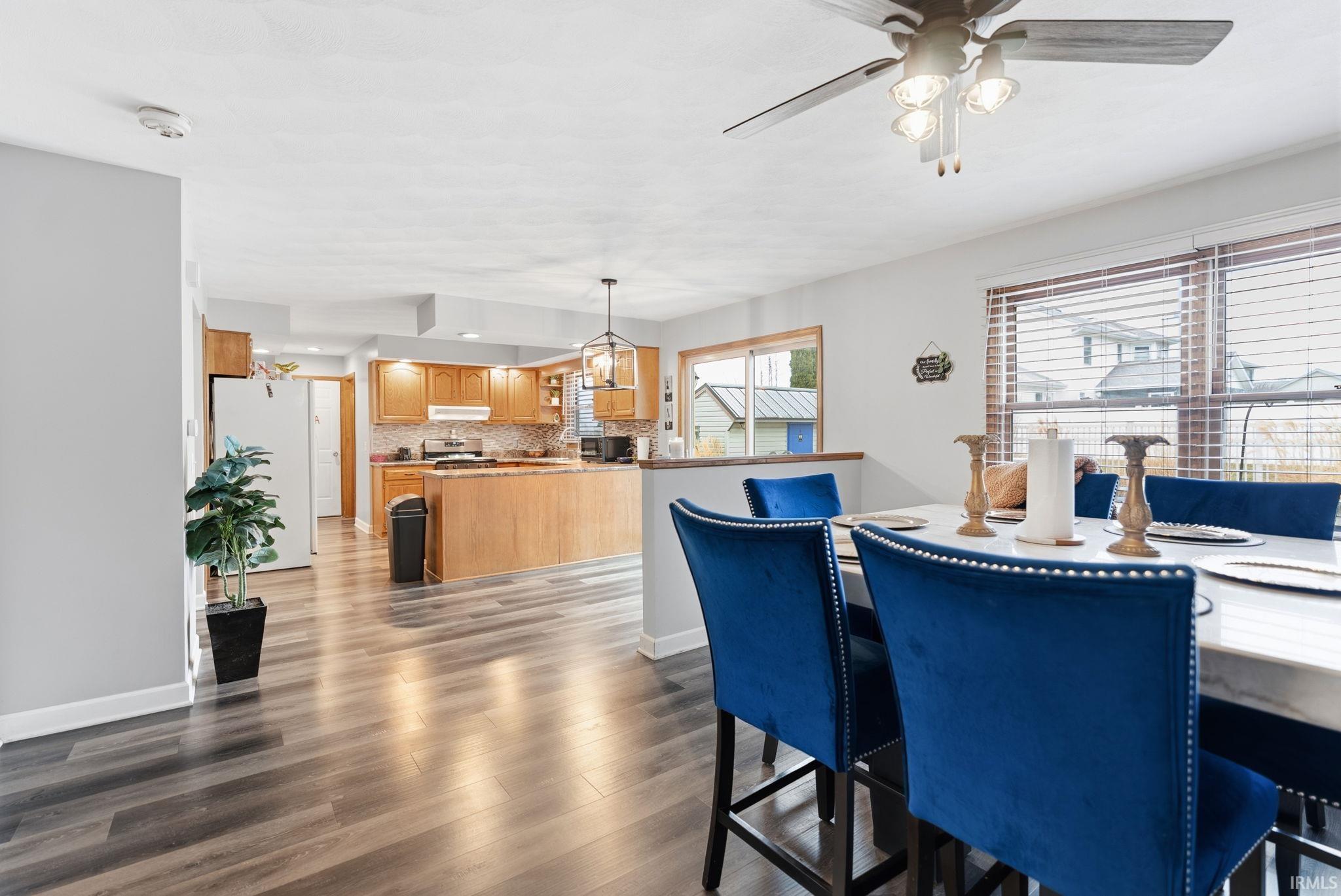 Dining area with dark wood-style flooring and a ceiling fan
