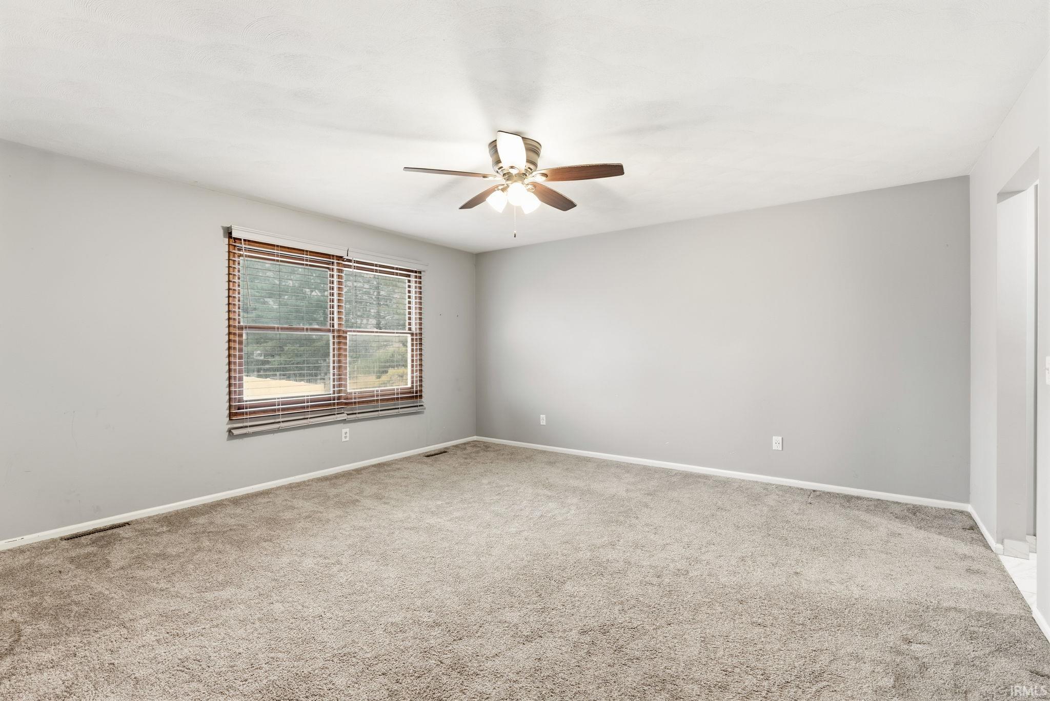 Spare room with light carpet and ceiling fan