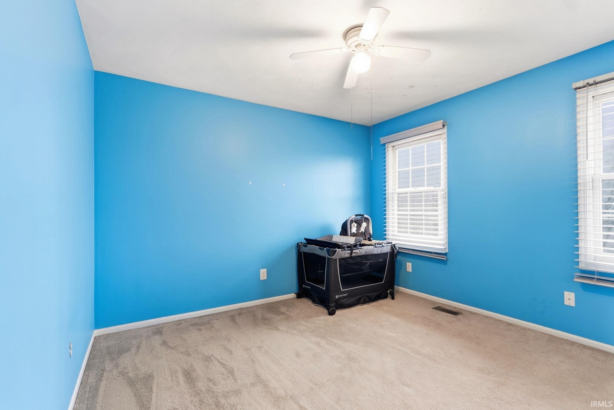 Empty room with carpet and a ceiling fan