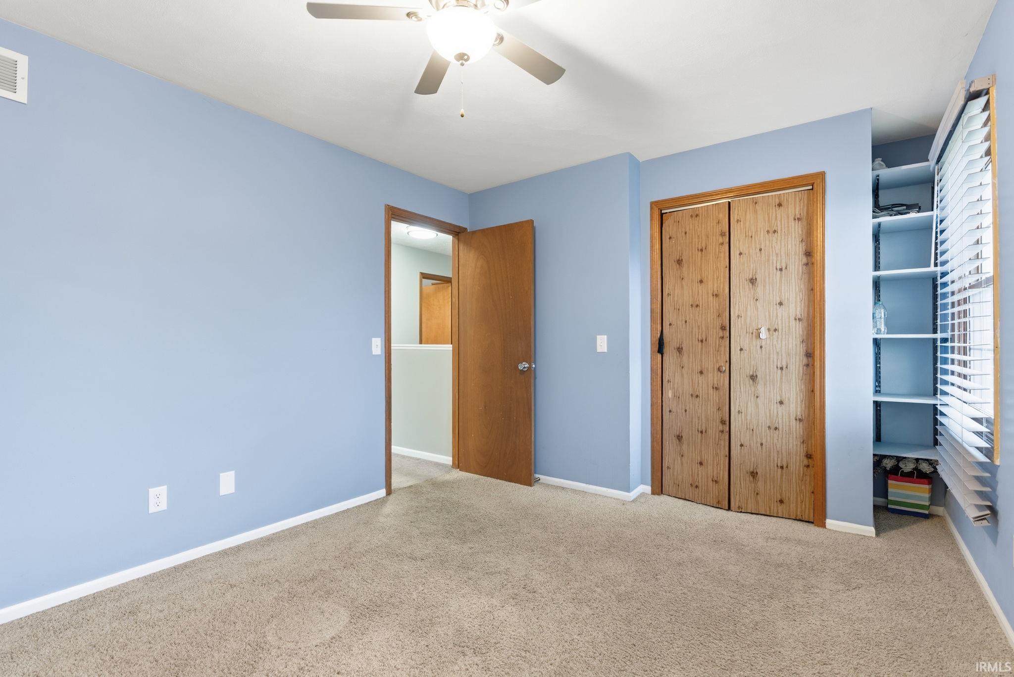 Unfurnished bedroom with carpet, a closet, and ceiling fan