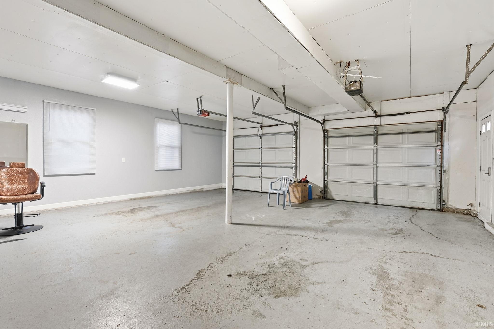 Garage with baseboards and a garage door opener