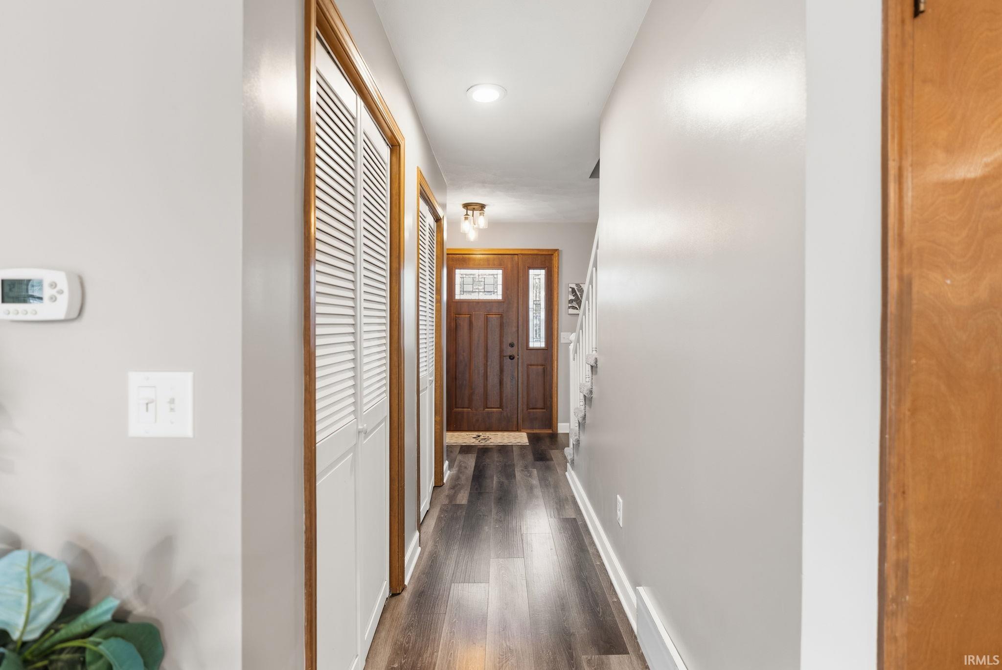 Hallway with dark wood finished floors and recessed lighting