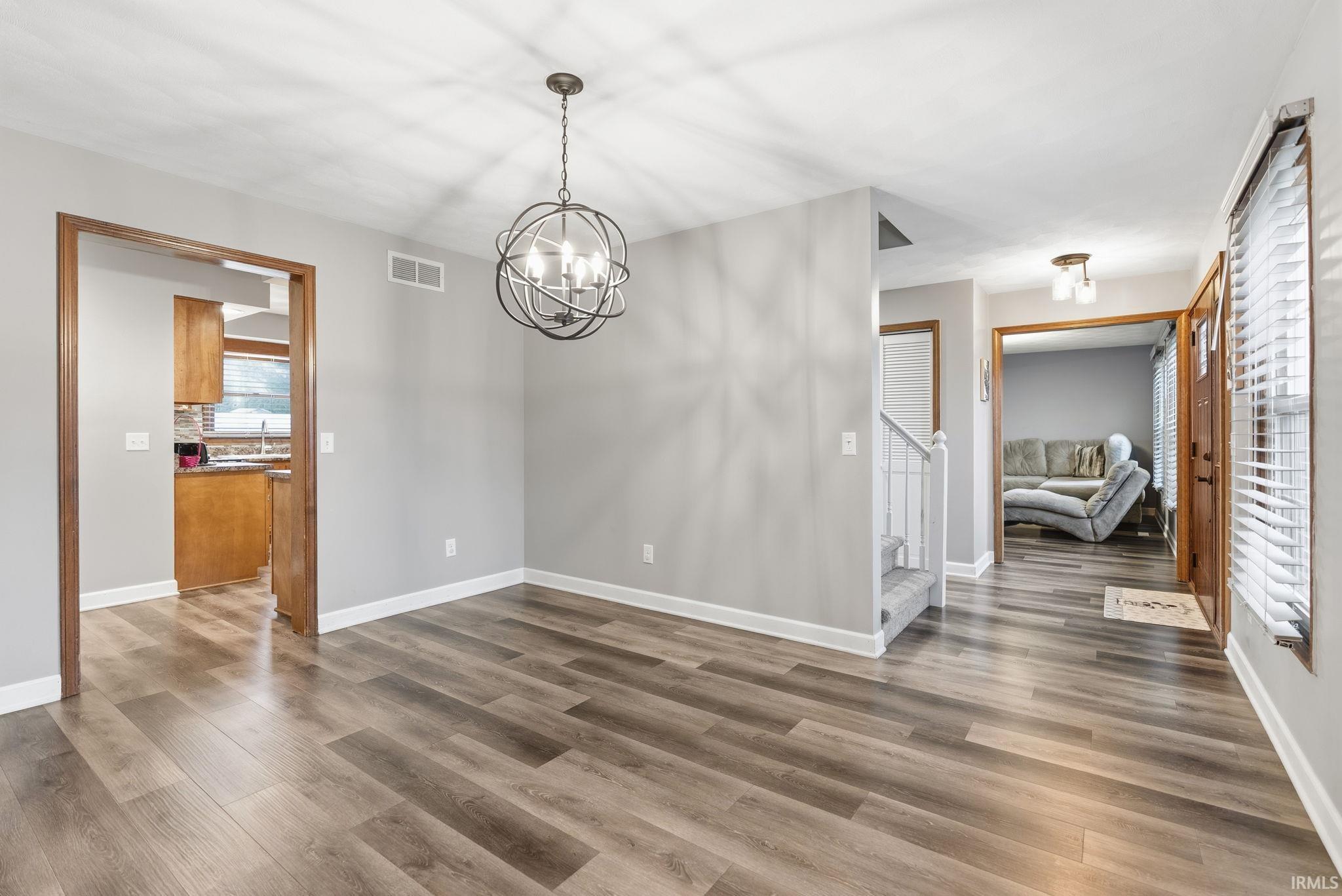 Unfurnished dining area featuring wood finished floors and hanging lights