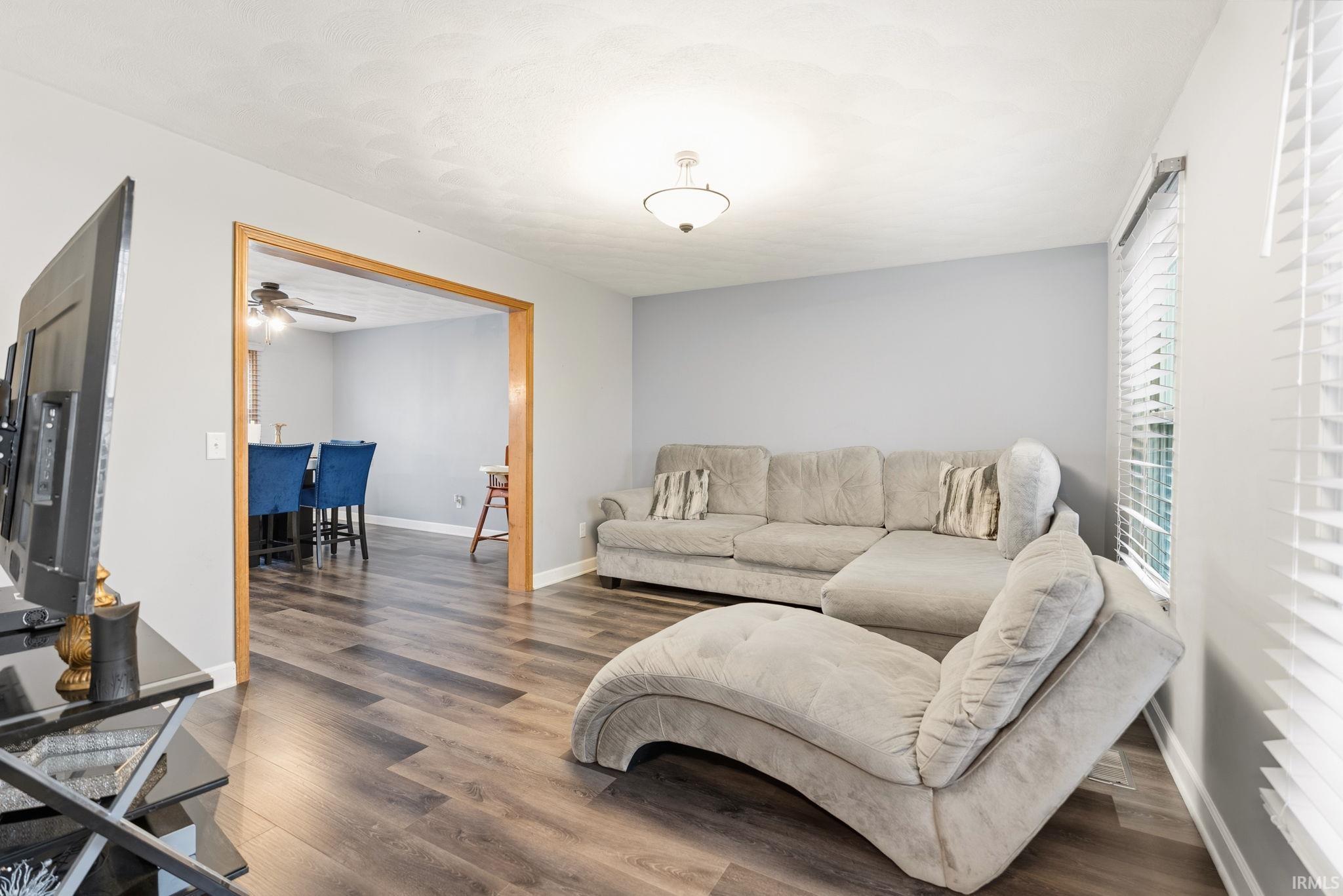 Living area with wood finished floors and a ceiling fan