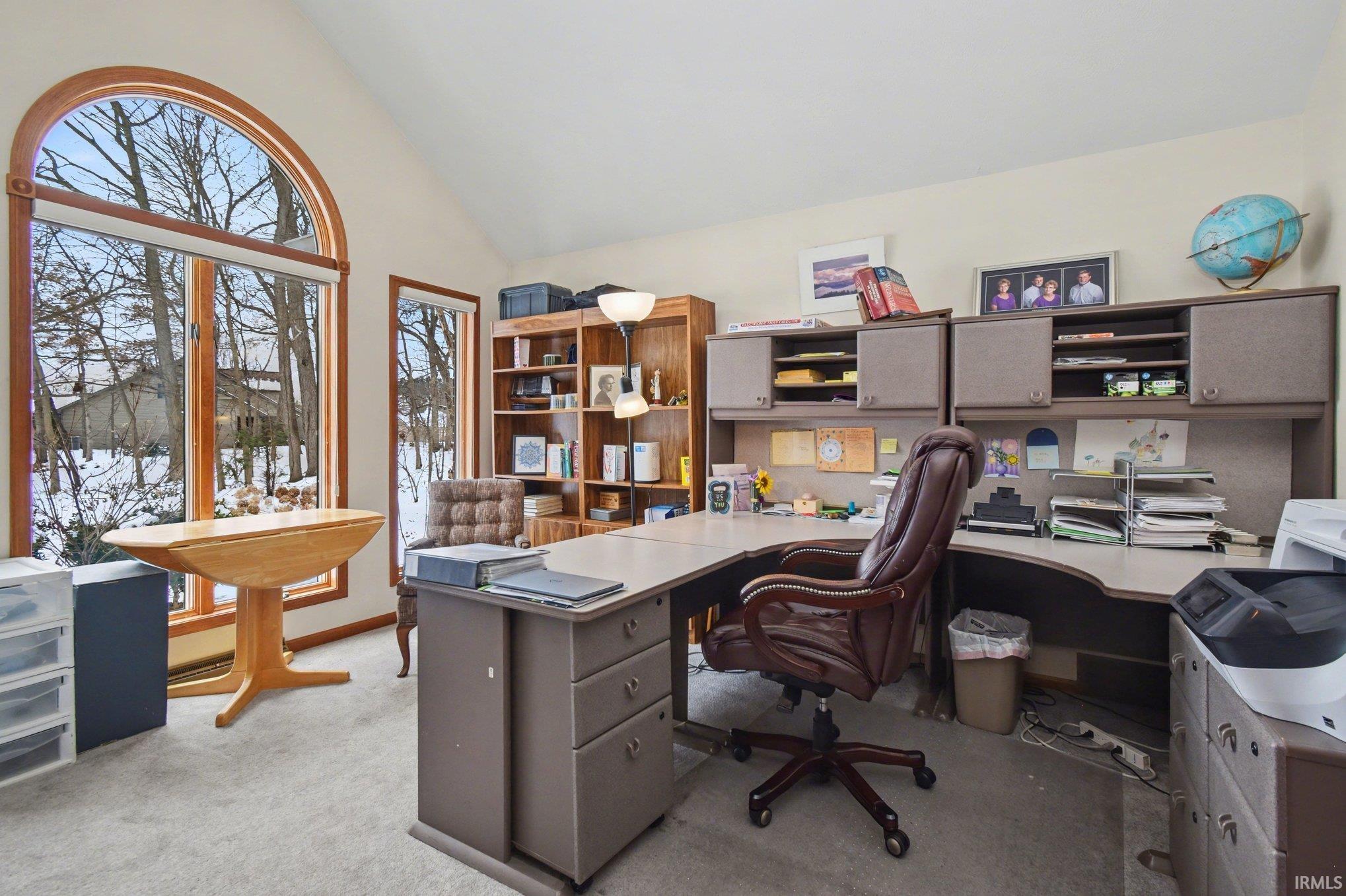Office area featuring lofted ceiling and light colored carpet