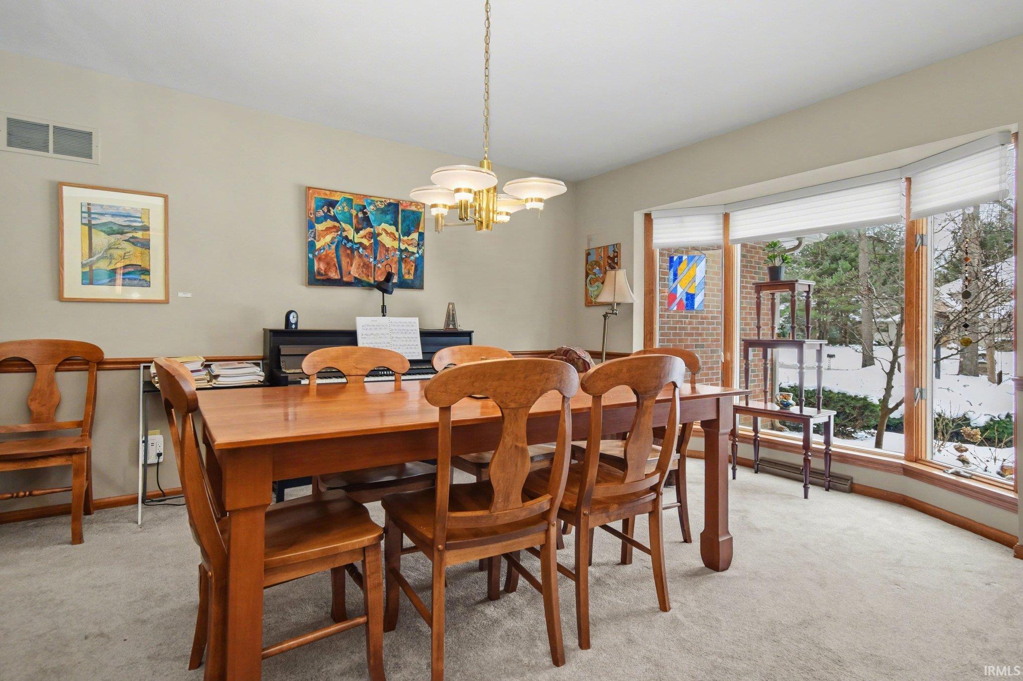 Dining room featuring light colored carpet and a chandelier