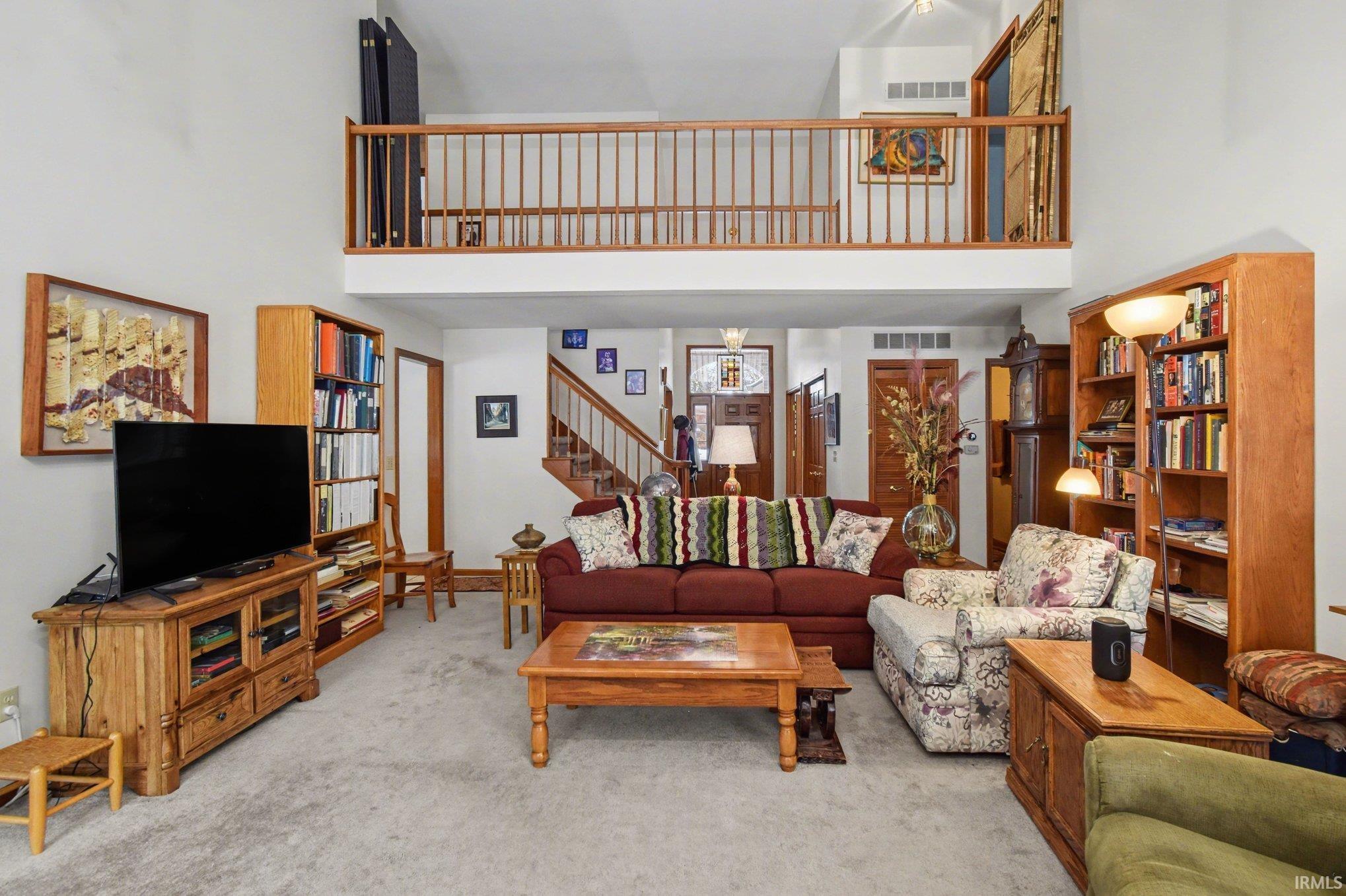 Living room featuring a high ceiling and carpet