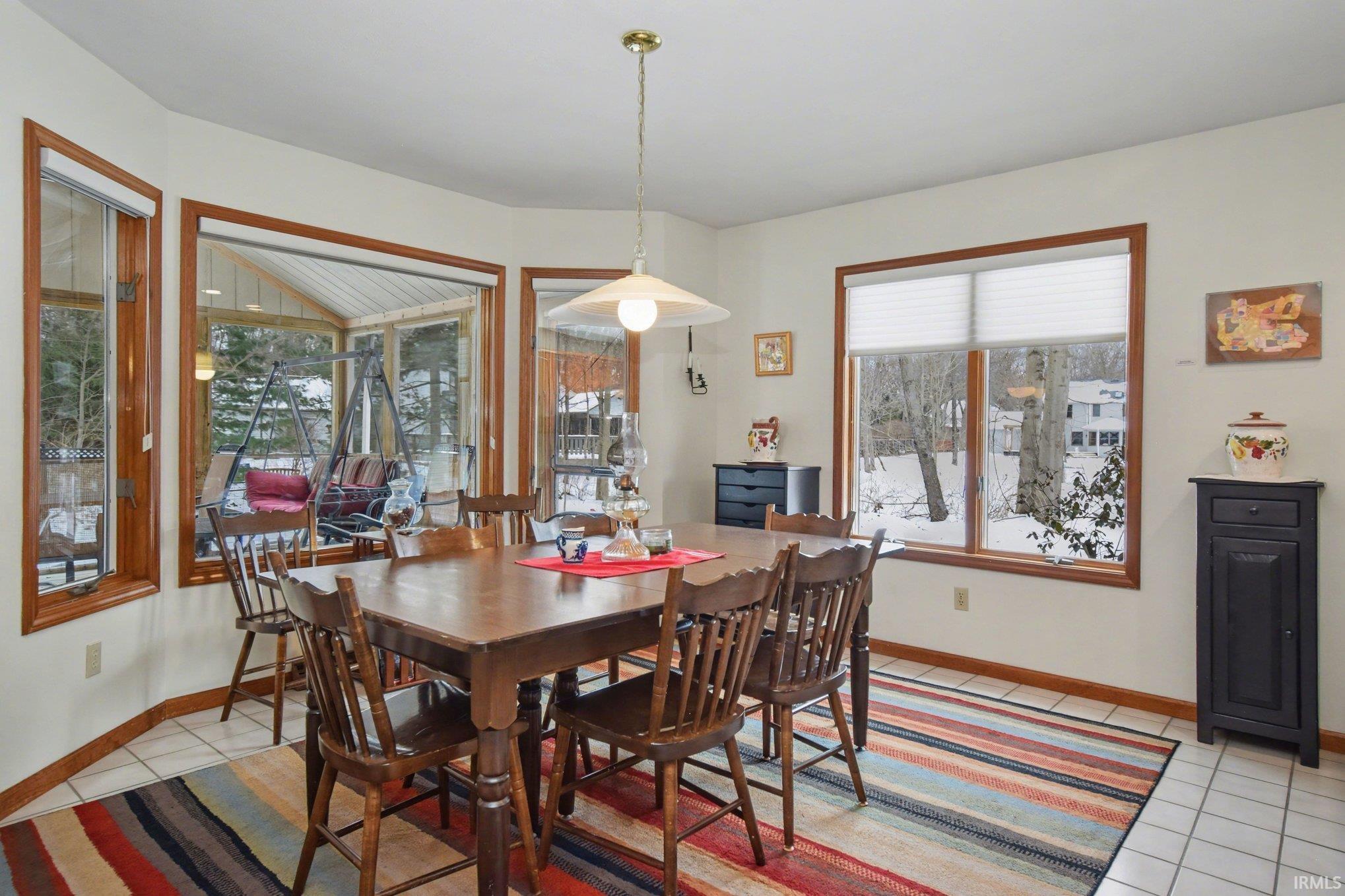 Dining space with light tile patterned floors and baseboards