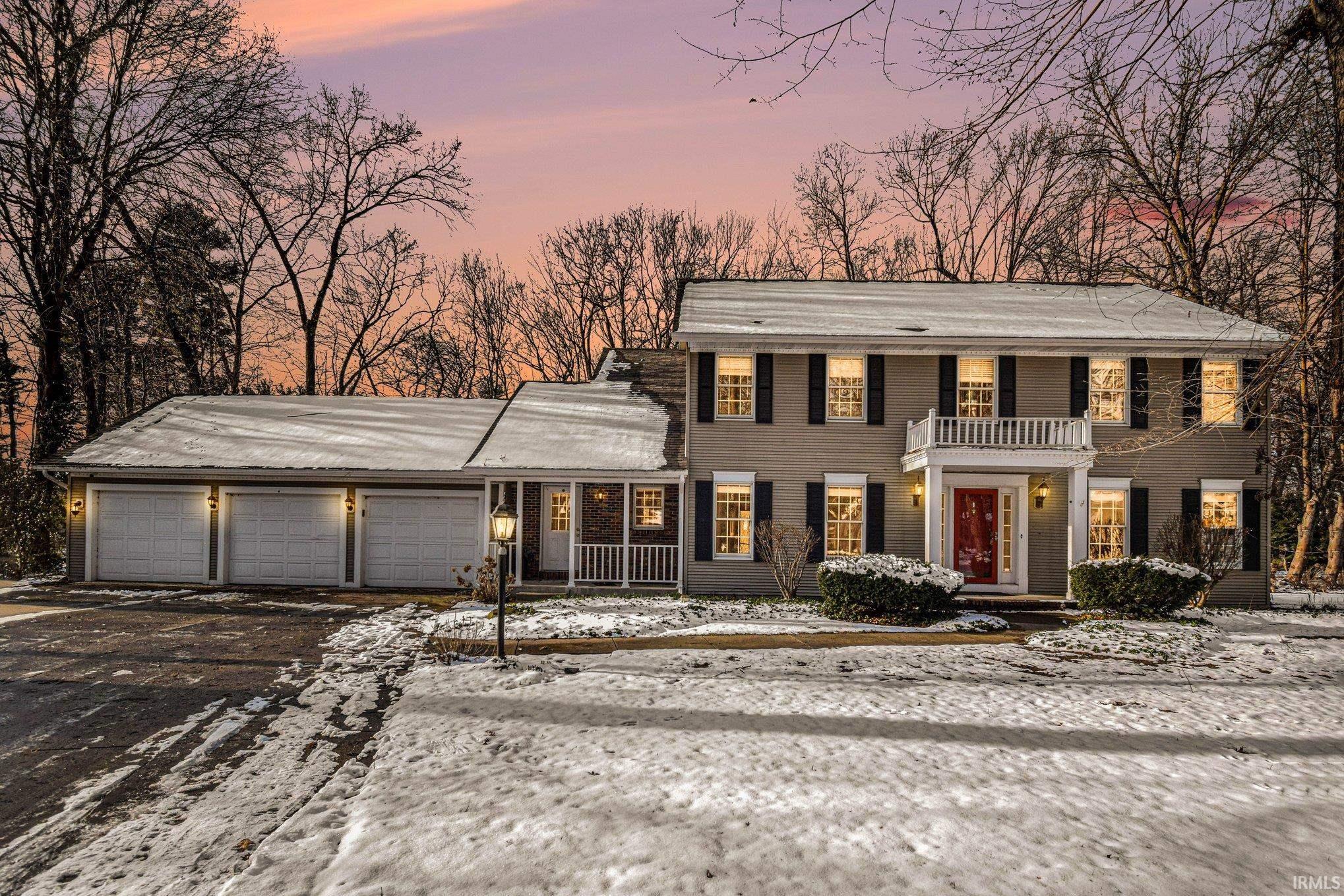 View of front of property with asphalt driveway and a garage