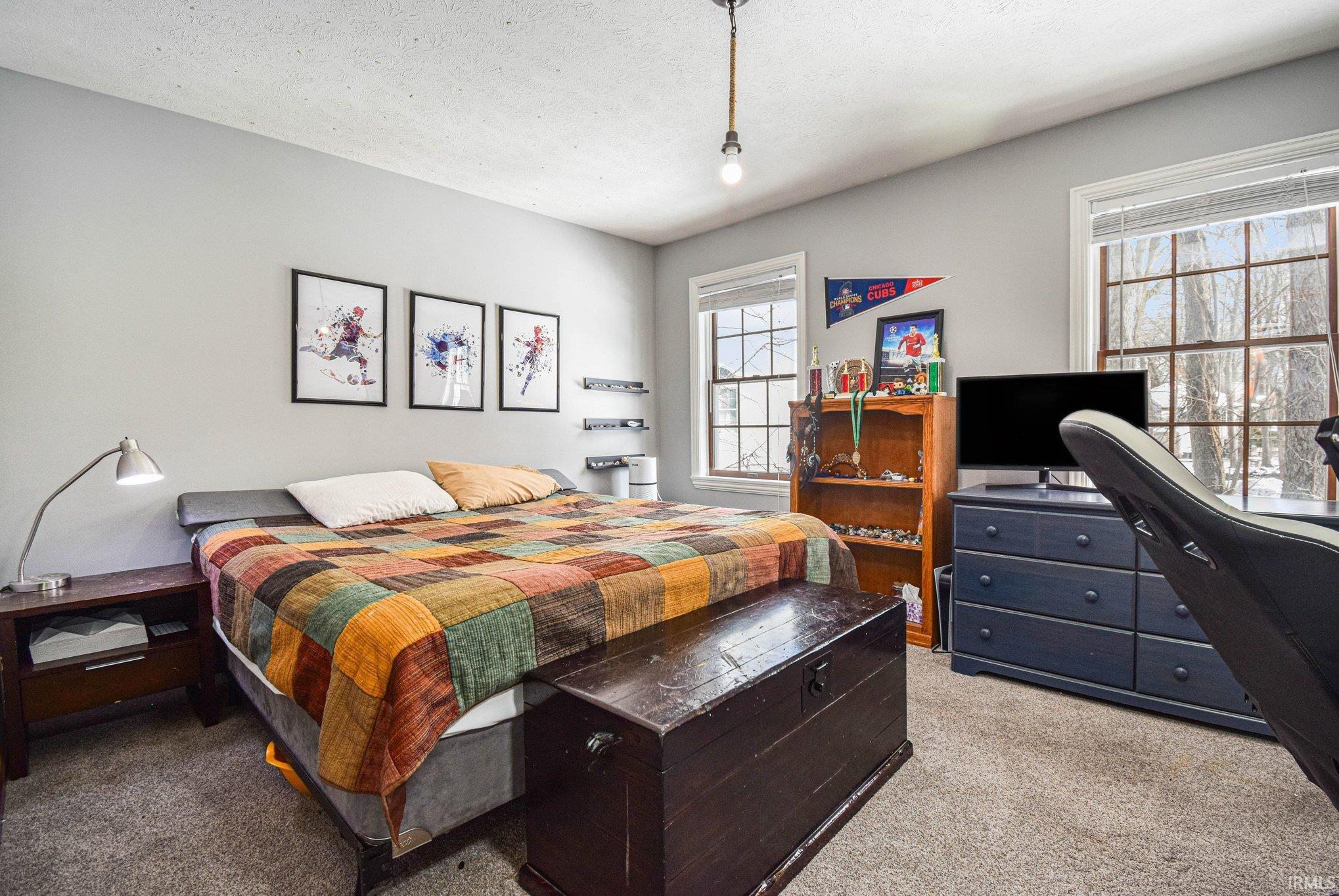 Bedroom featuring light carpet and a textured ceiling