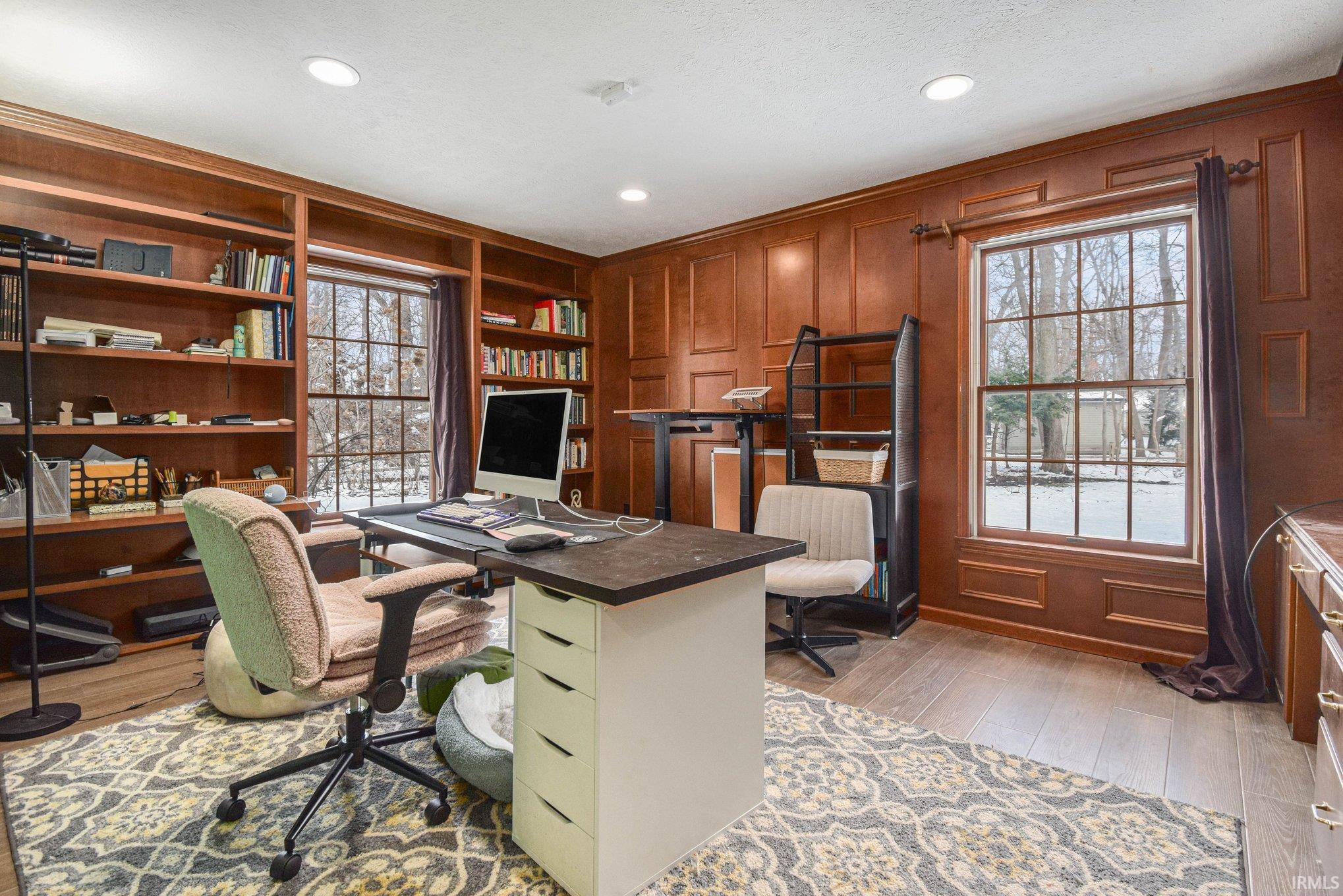 Office area featuring a decorative wall, light wood finished floors, built in features, and recessed lighting