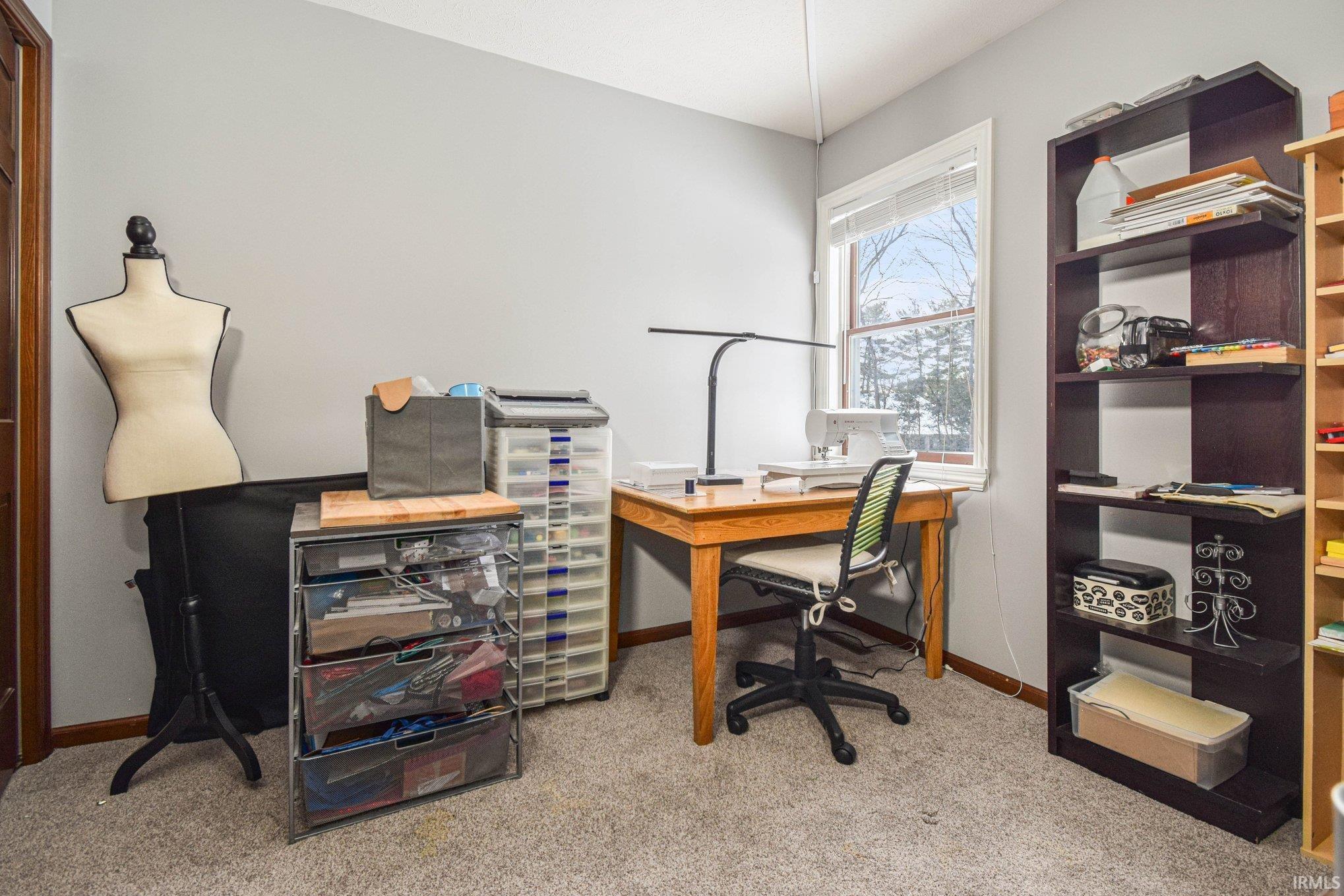 Office space with light carpet and baseboards