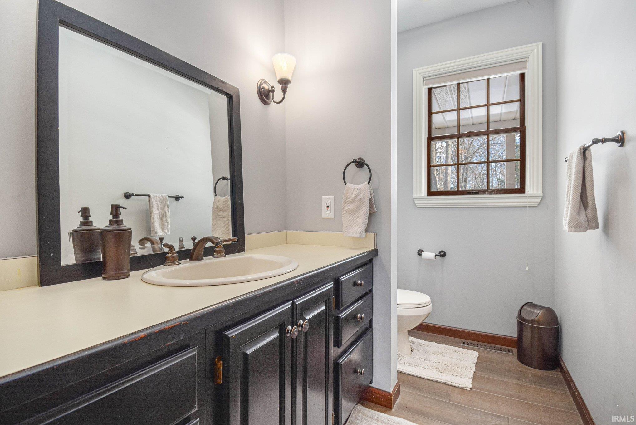 Half bathroom with vanity and light wood-type flooring