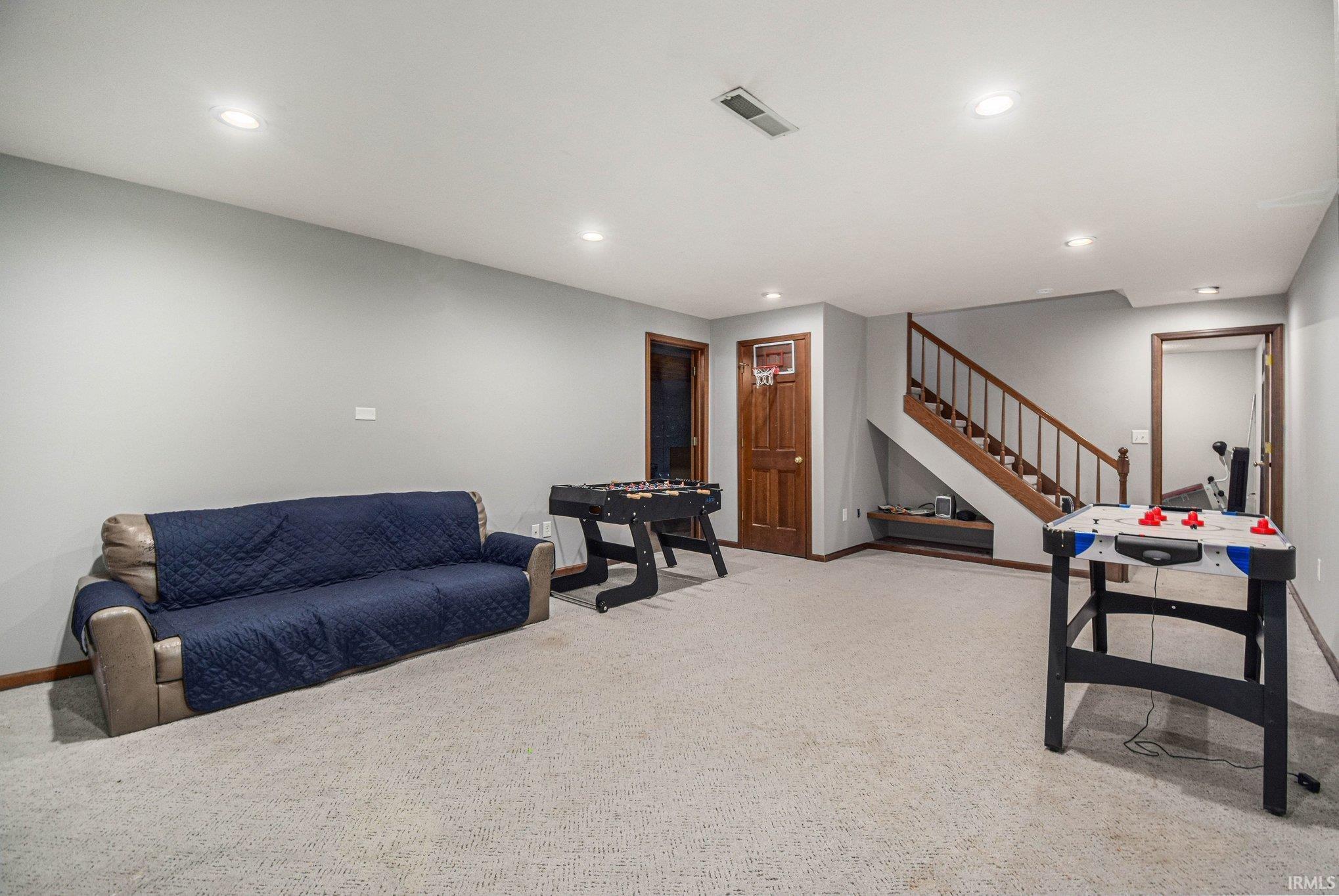 Living area featuring light colored carpet and recessed lighting